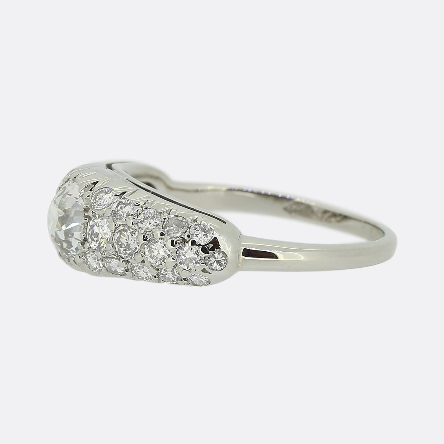 Here we have a stunning diamond cluster ring crafted at a time when the Art Deco style was at the forefront of design. This piece has been crafted from 14ct white gold and showcases a single round faceted old mine cut diamond which sits slightly