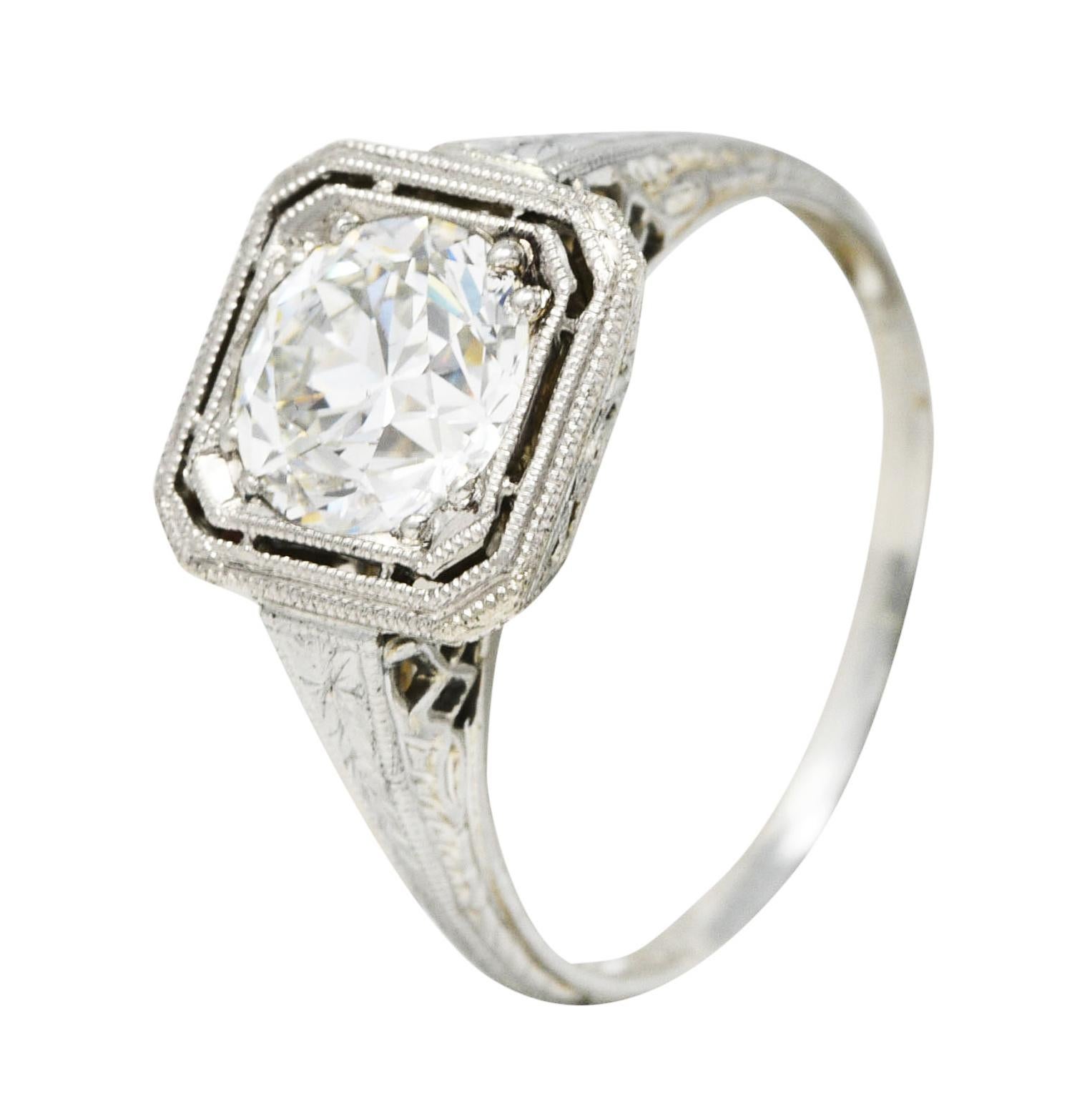 Centering an old European cut diamond weighing 1.34 carat total - J color with SI1 clarity. Bead set in an octagonal form head with milgrain surround. Flanked by engraved wheat motif shoulders. Accented by a pierced lattice style gallery. Tested as