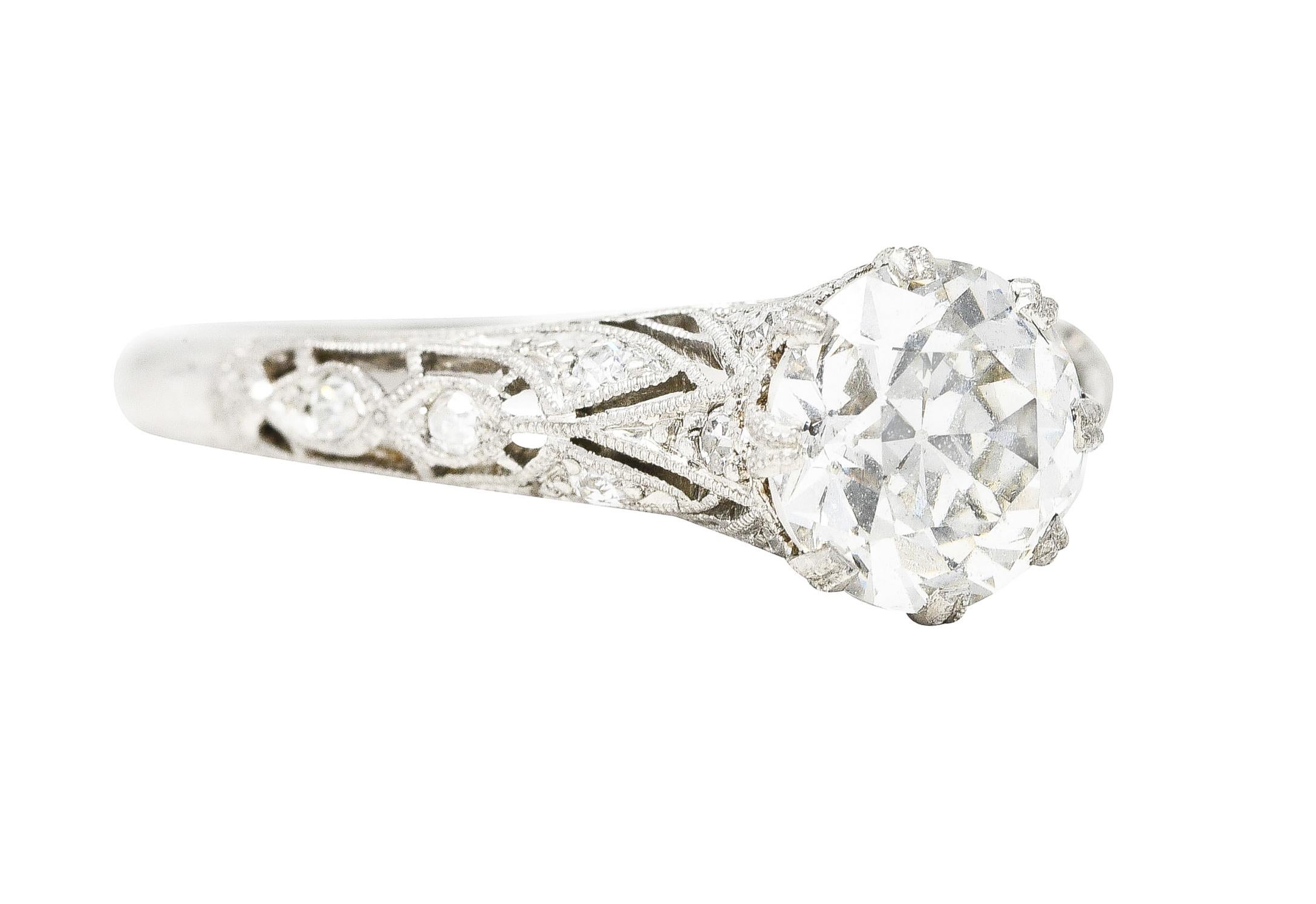 Centering an old European cut diamond weighing 1.20 carats total - I color with VS2 clarity. Prong set by eight milgrain prongs with an intricate pierced trellis surround and marquis shoulders. Featuring single cut diamonds bead set throughout with