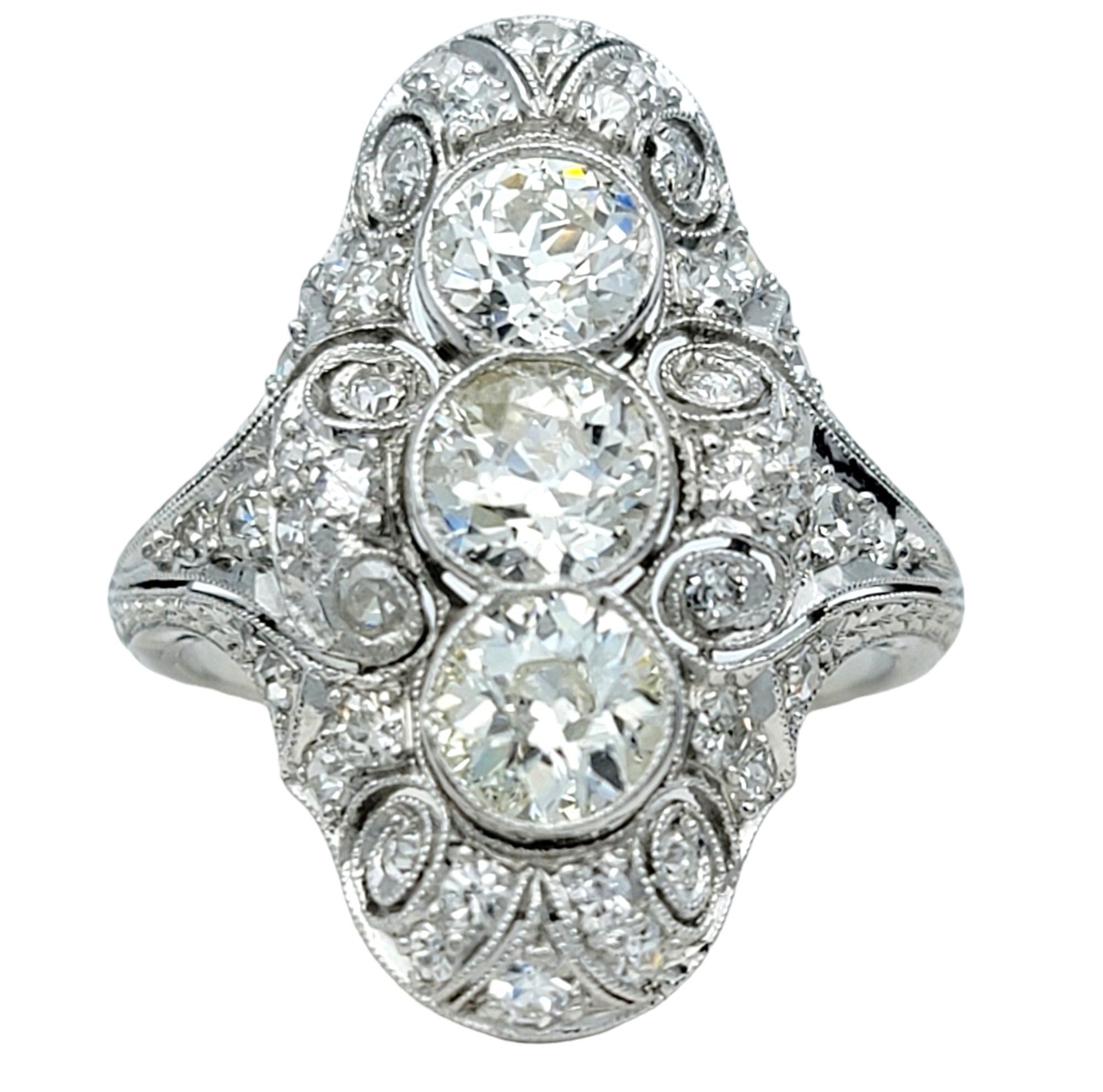 Ring Size: 7.75

This exquisite art deco era diamond ring exudes timeless elegance and sophistication. Set in platinum, it features three larger old European cut diamonds arranged in a row along the center, creating a stunning focal point.