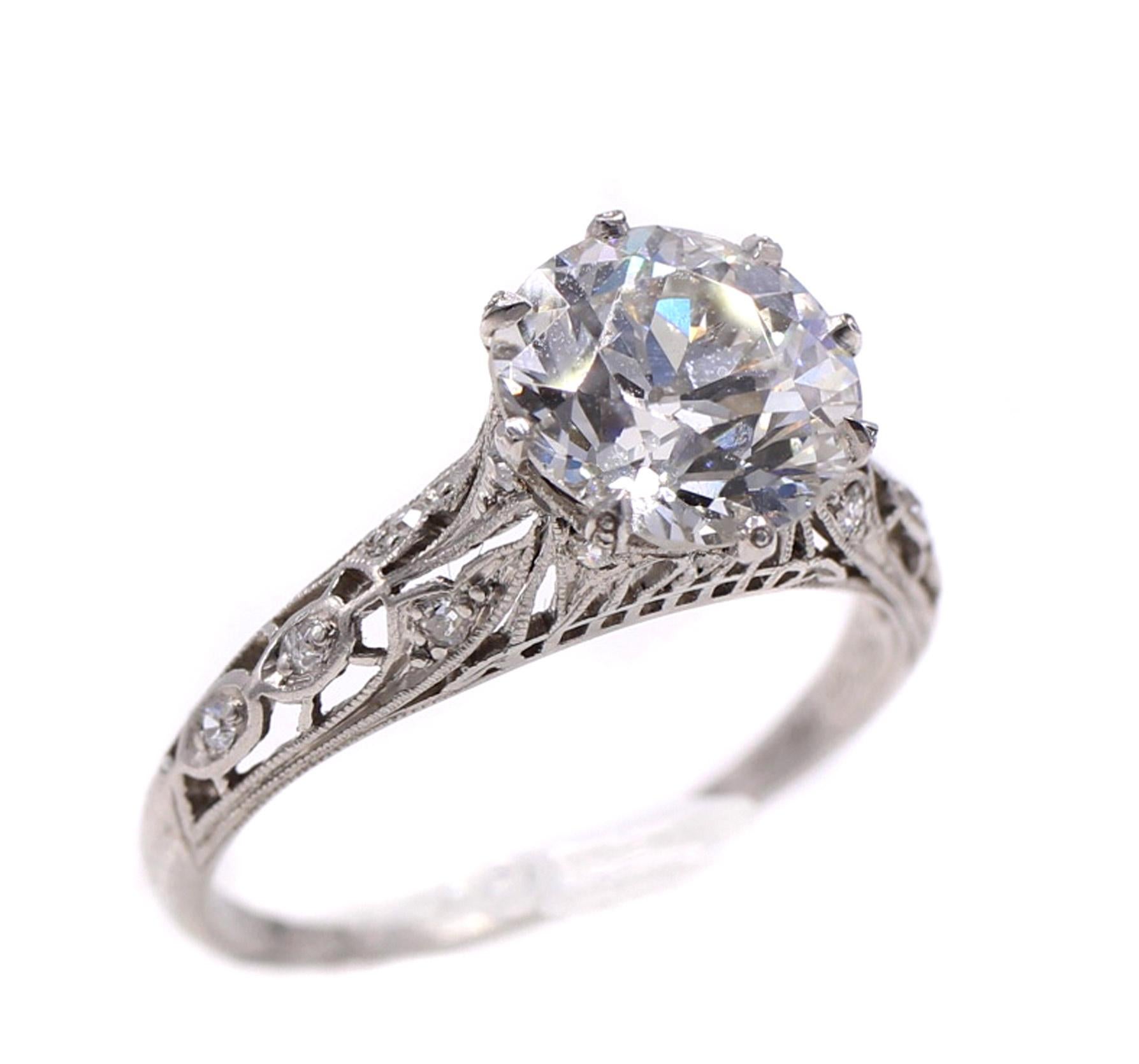 Beautifully designed and masterfully handcrafted this platinum ring features fine ajour and milligrain work throughout the gallery and shank. Embellished by small round old cut diamonds, the center Old European cut diamonds shows off an amazing