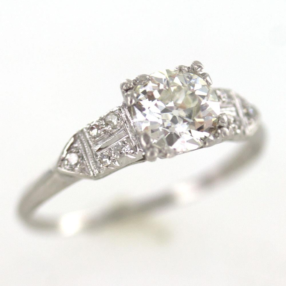 Bright Old European Cut Diamond Center is set in a hand made platinum mounting circa 1920-1930's. The mounting features 10 side diamonds (.10 carat total weight). The center 1.02 carat Old European Cut diamond is graded K color and VS2 clarity by