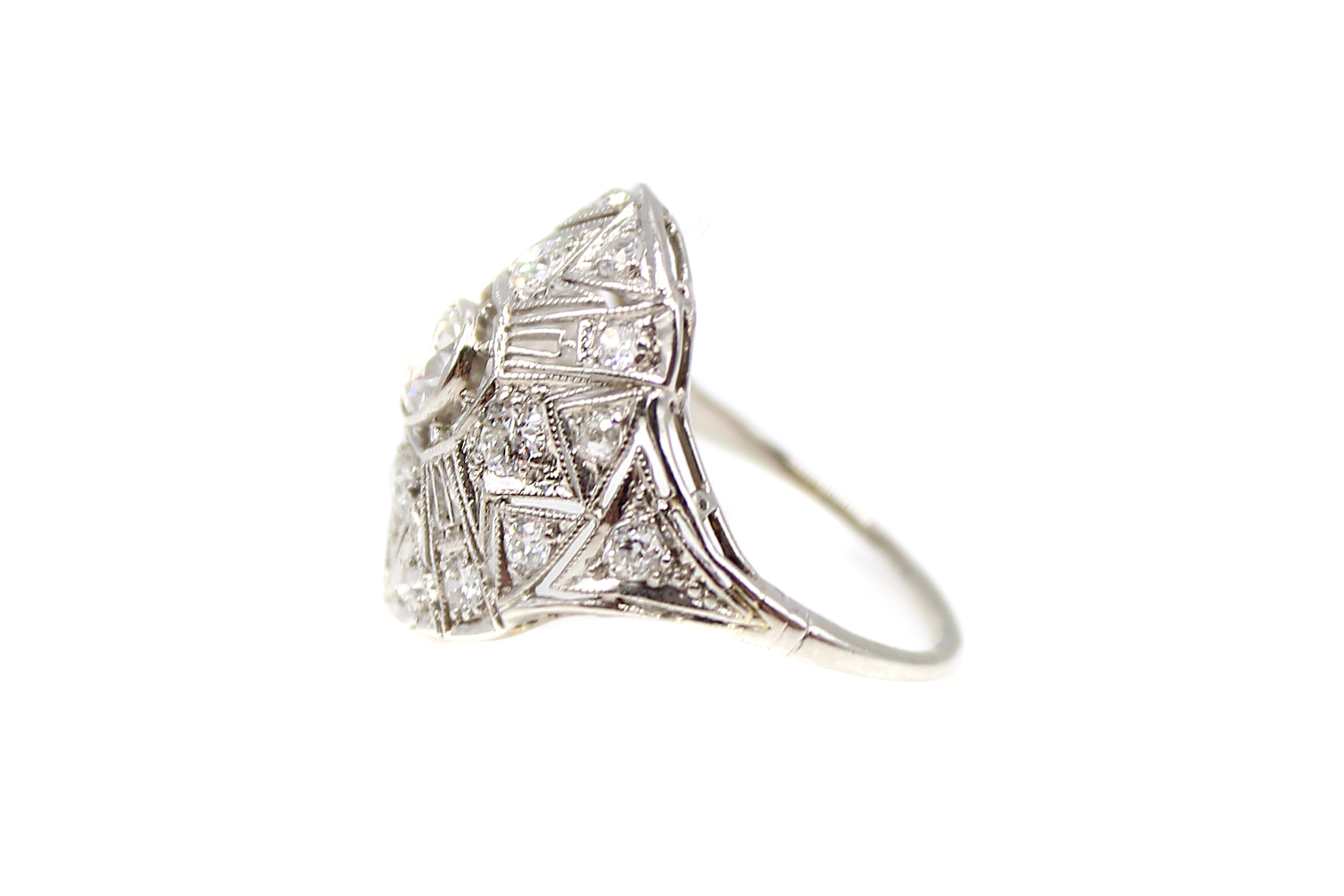 Gorgeous Art Deco platinum diamond ring centrally set with an Old European cut diamond weighing approximately 0.50 carats. The center diamond is embellished by 18 smaller bright white Old European cut  diamonds set in between beautiful azur work in