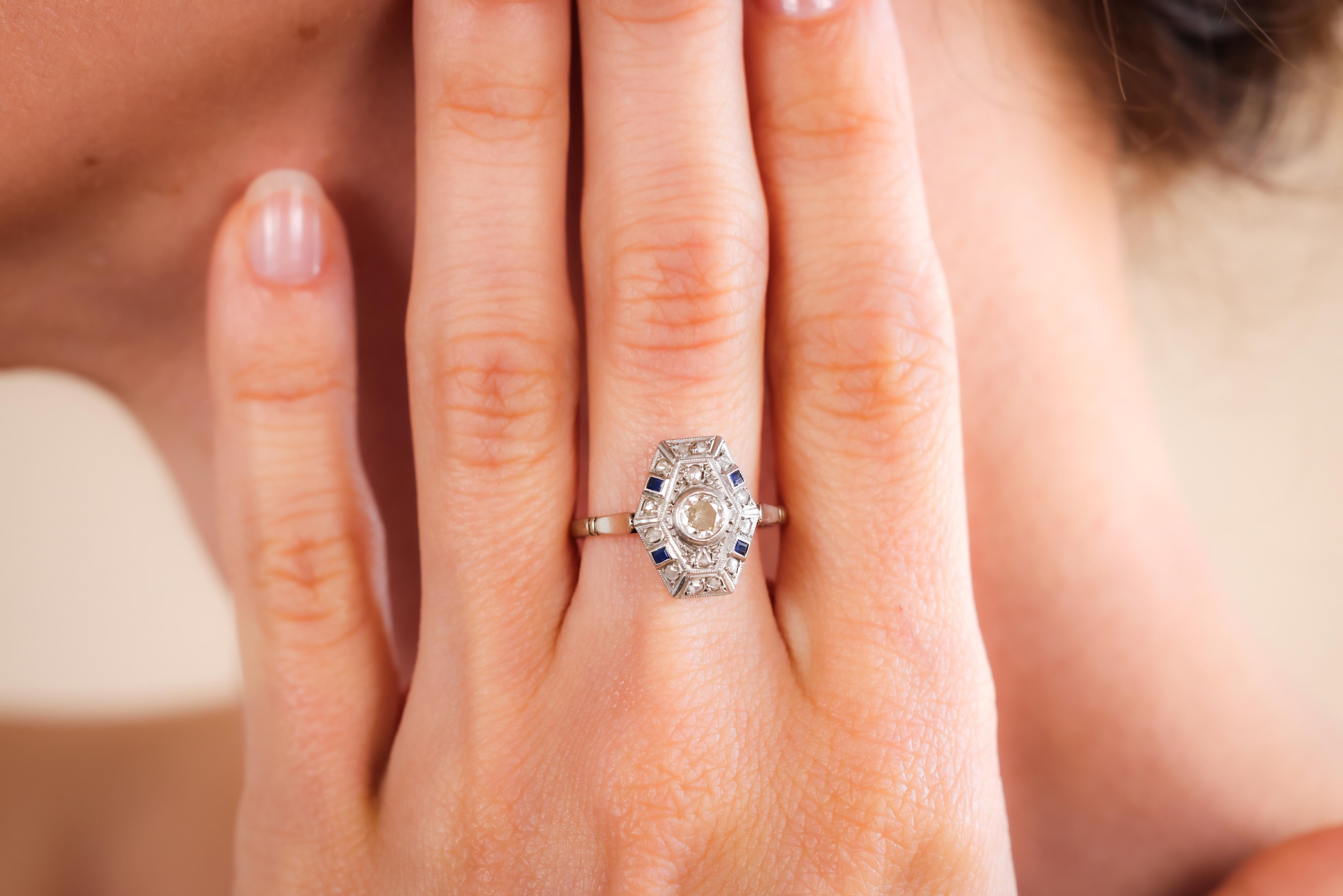 Mittelstein: Diamant
Schnitt: Alteuropäischer Schliff
Gewicht: Ungefähr 0,25 Karat
Farbe: I
Klarheit: VS
Akzentuierungsstein: 14 Diamanten
Schnitt: Rosenschliff
Gewicht: Ungefähr 0,15 Karat
Farbe: I
Klarheit: SI
Akzentuierungsstein: 4