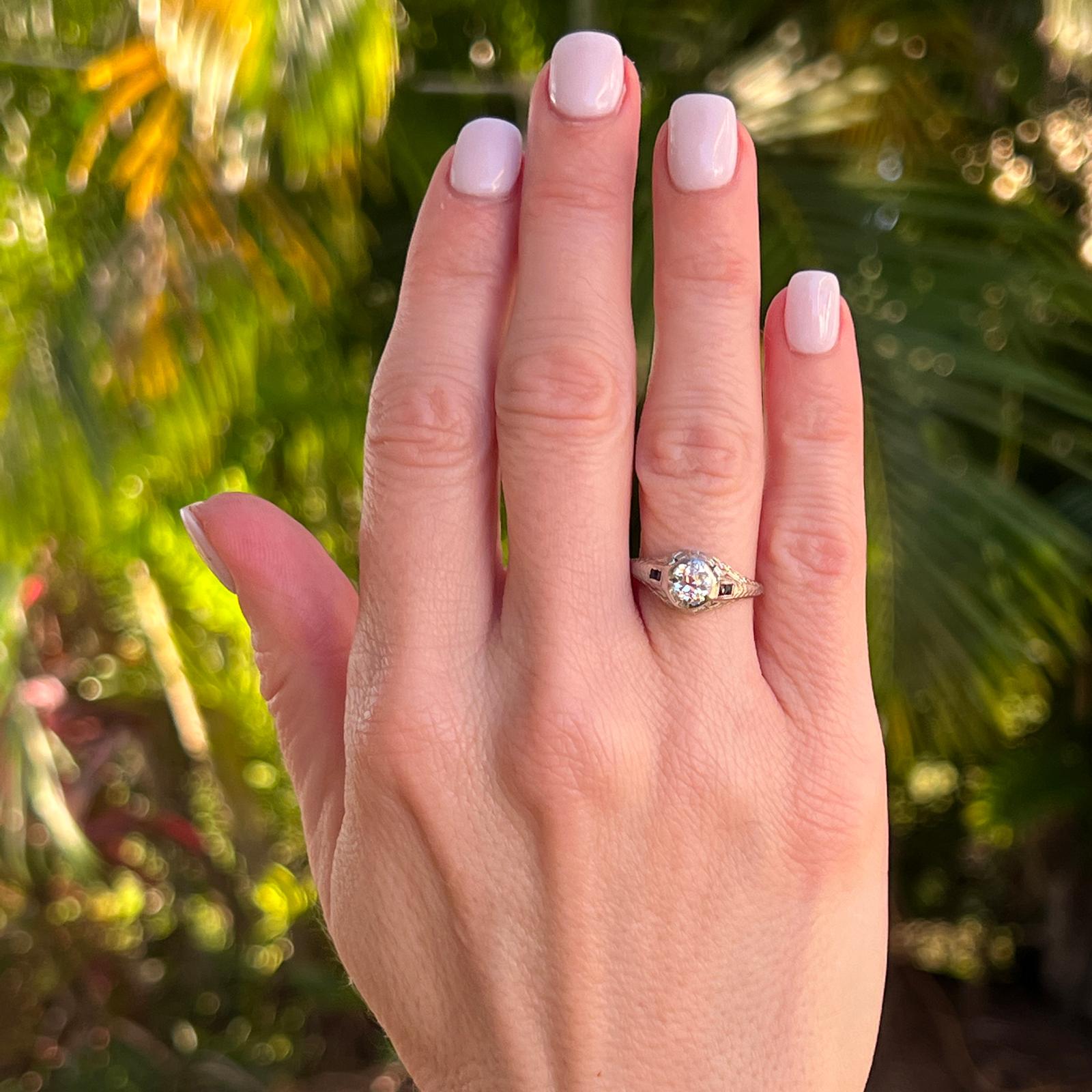 Original Art Deco Diamant-Verlobungsring, handgefertigt in Platin. Der Ring ist mit einem etwa 0,70 Karat schweren Diamanten im alten europäischen Schliff mit der Farbe H und der Reinheit VS versehen. Der Diamant ist von 4 blauen Saphiren umgeben.
