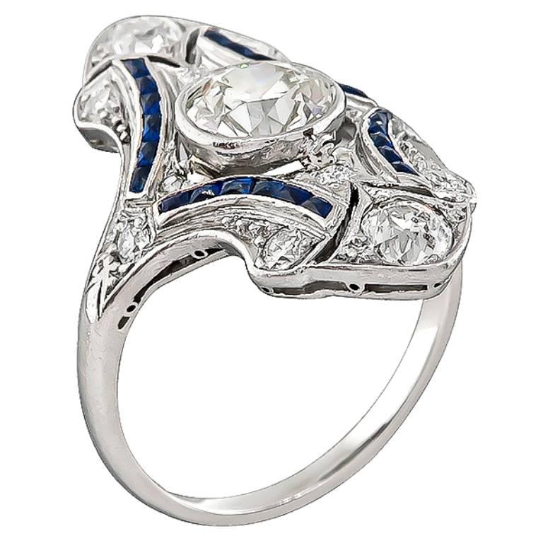 This elegant platinum ring from the Art Deco era is centered with a sparkling old European cut diamond that weighs approximately 1.00ct. graded K color with VS1 clarity. The center diamond is accentuated by old mine cut diamonds that weigh