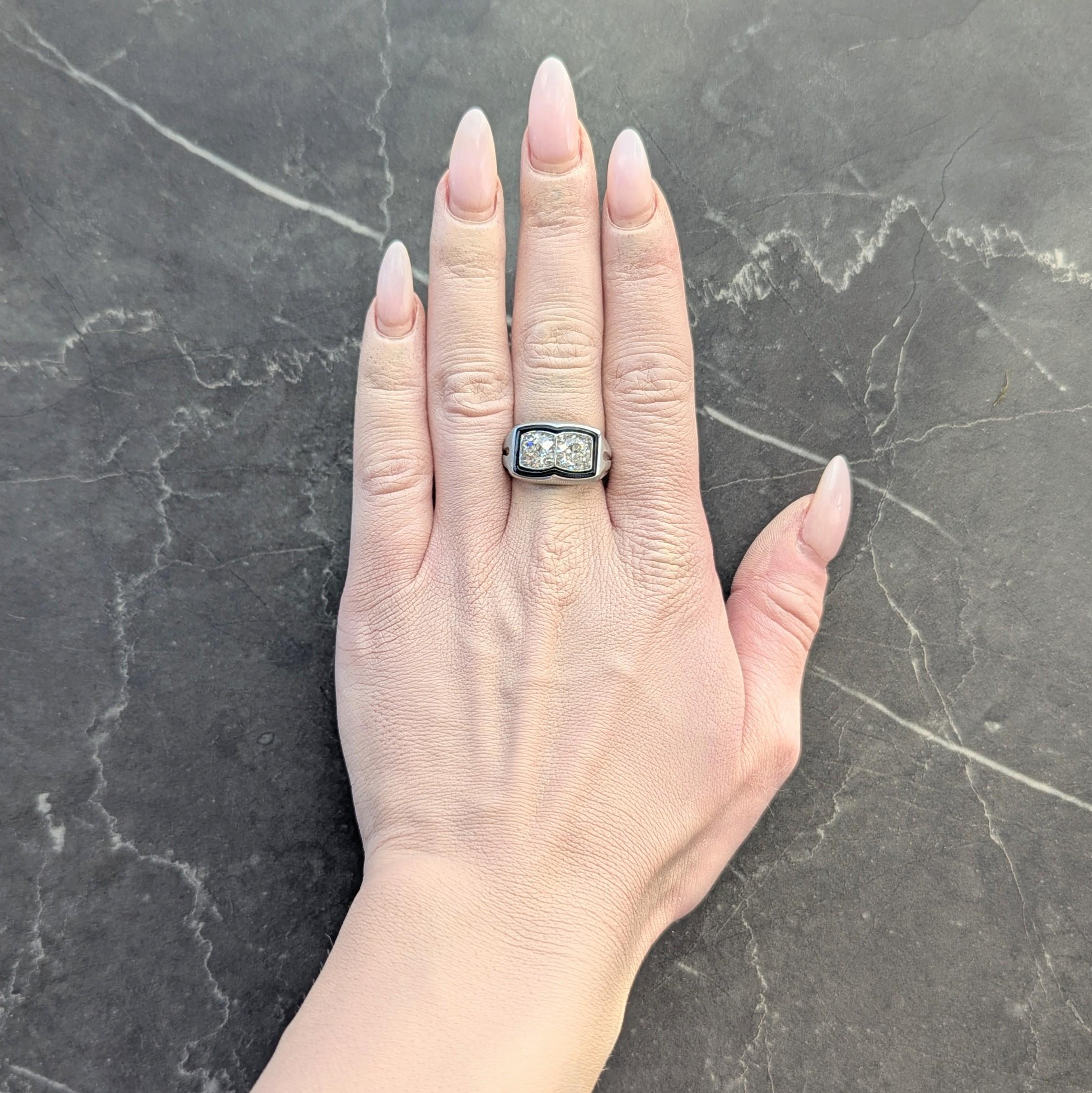 Au centre, deux diamants de taille européenne ancienne d'un poids total d'environ 2,00 carats.
Couleur I et pureté SI1 - perle d'est en ouest en forme de coussin
Avec un halo d'émail noir entouré d'un contour aux formes
Couleur noire opaque et