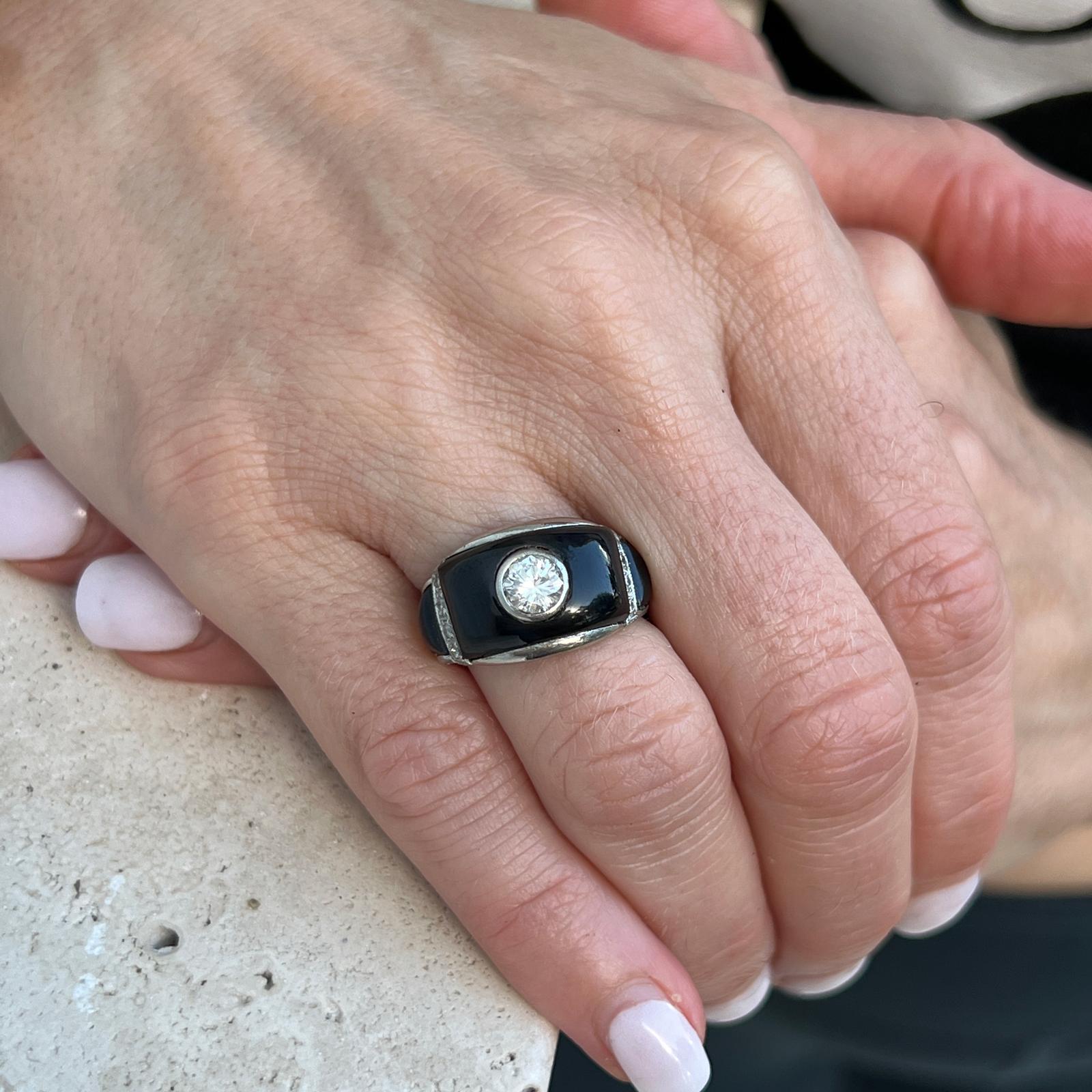 Beautiful Art Deco diamond and onyx cocktail ring handcrafted in platinum. The ring features a bezel set Old European cut diamond weighing approximately .60 carats, and another 8 side diamonds weighing another .12 carats. The diamonds are graded F-G