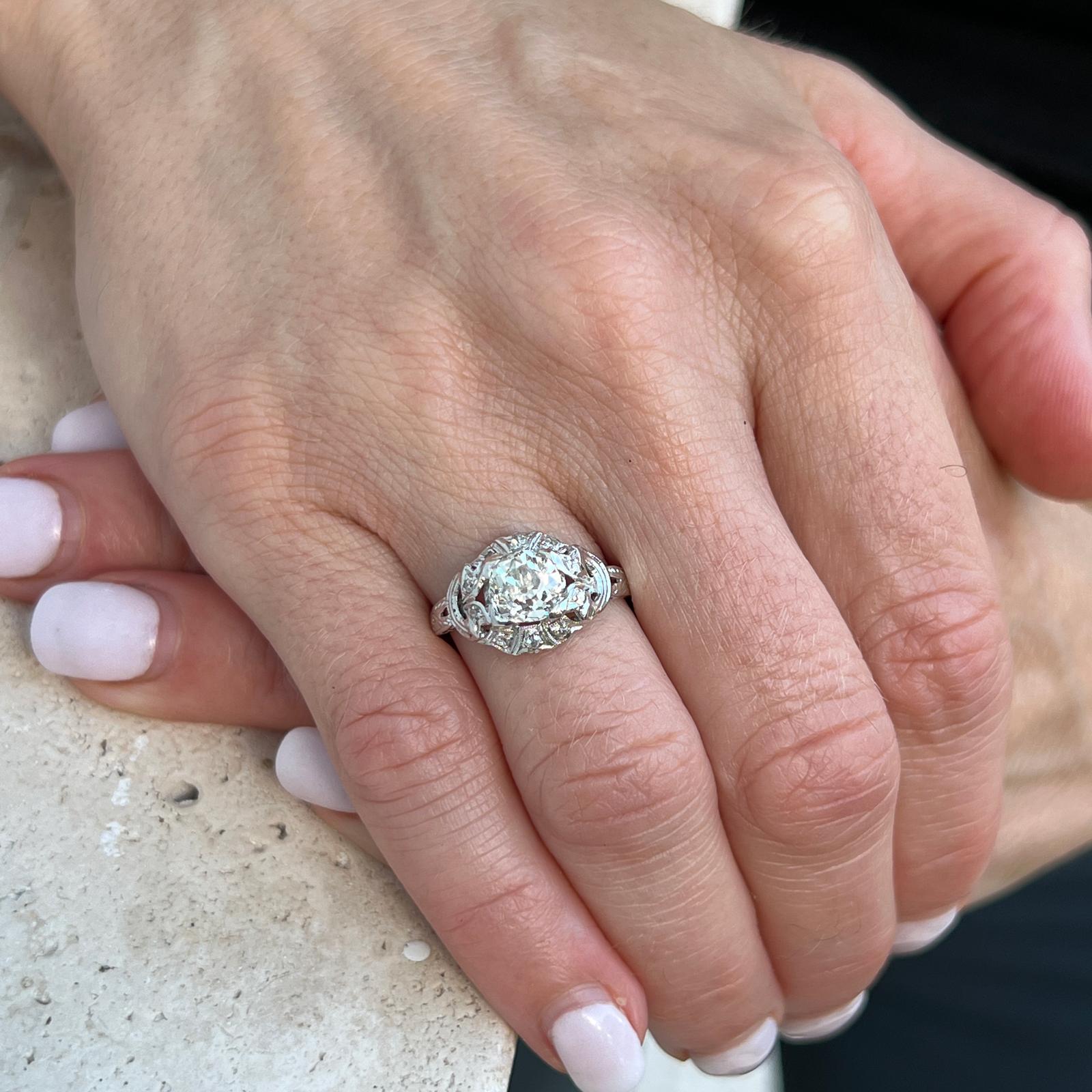 Original Art Deco diamond engagement ring handcrafted in platinum. The ring features an approximately 1.35 carat Old European cut diamond, and 20 surrounding diamonds weighing another .20 carats. The diamonds are graded G color and SI-I1 clarity.