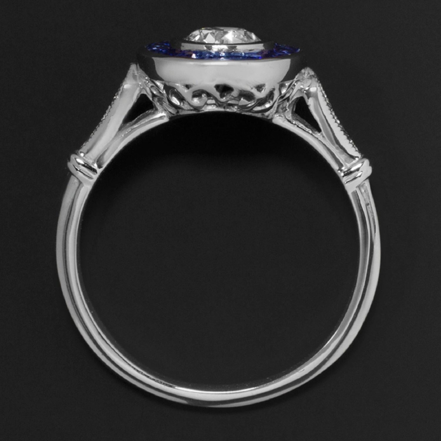 Art Deco style ring features a very high quality ½ carat old European cut diamond surrounded by a glamorous ring of royal blue natural sapphires. Bright white and completely eye clean, the GIA certified F SI1 diamond is gorgeously vibrant. Cut by