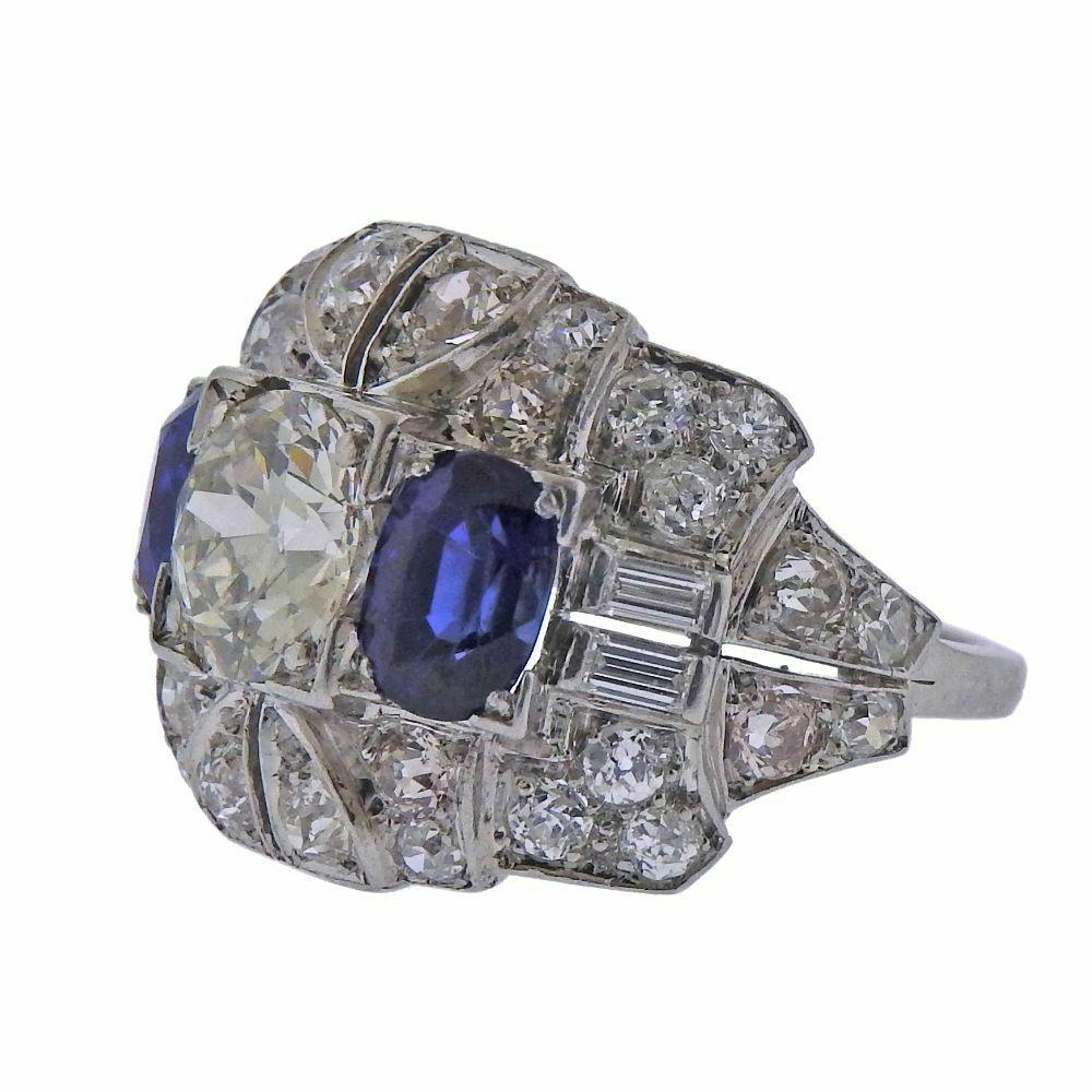 Gorgeous art deco ring featuring a 1.70ctw -1.80ct J/VS2 old european cut center stone, sapphires and approximately 1.80ctw of surrounding diamonds. Ring size 6.5, top is 17mm wide. Tested platinum. Weight is 9.5 grams. 