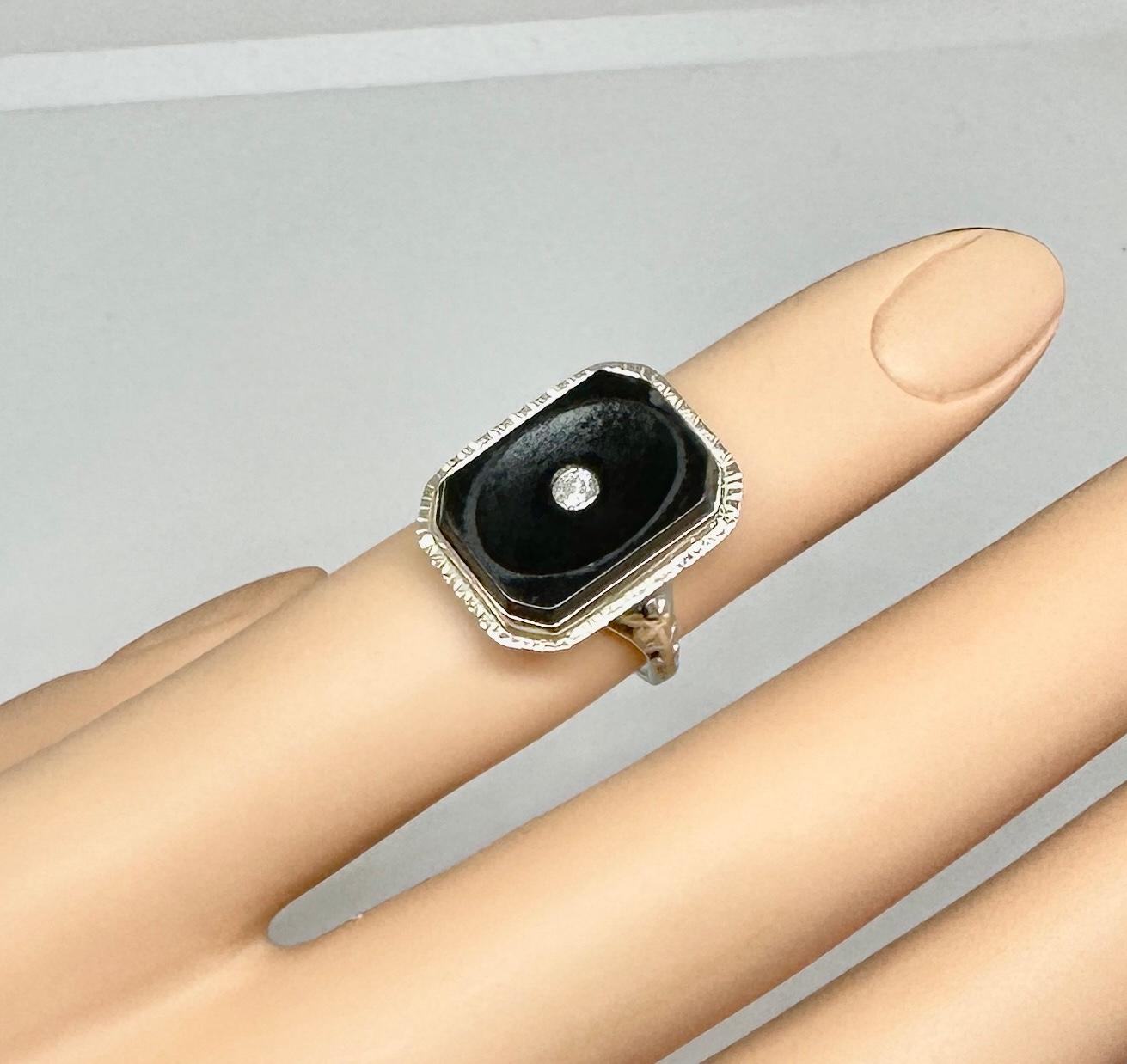 This is a very special Edwardian, Art Deco Ring with a rectangular Black Onyx, a central Old Mine Cut Diamond and beautiful 10 Karat White Gold work around the stunning gallery and extending down the ring shank.  The magnificent antique ring has a