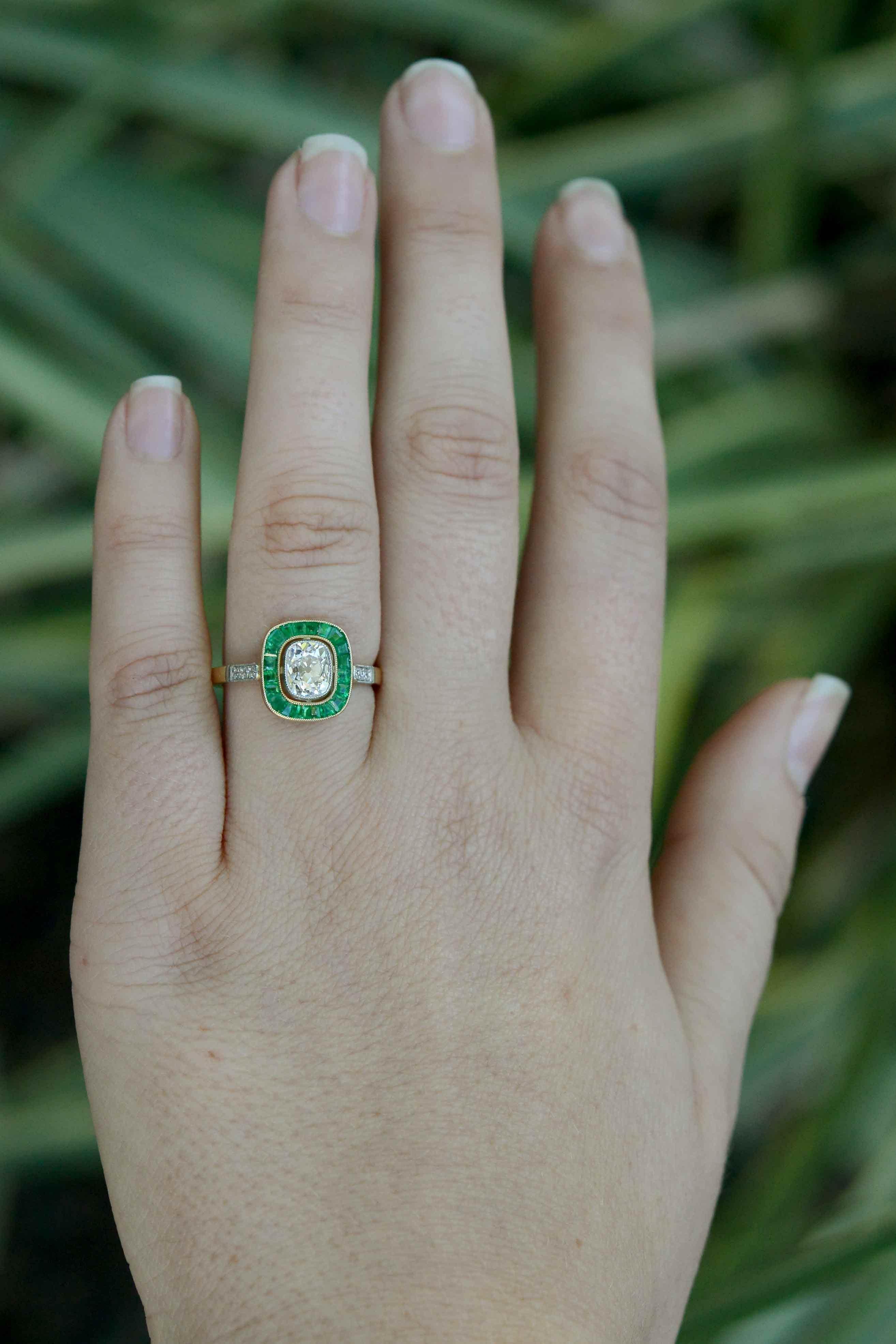 With a breathtaking, glittering old mine cut cushion diamond taking center stage, the French-cut calibre' emerald halo surround really adds the wow factor. Owing its artful flare to the Art Deco era, this lovingly handmade gold and platinum antique