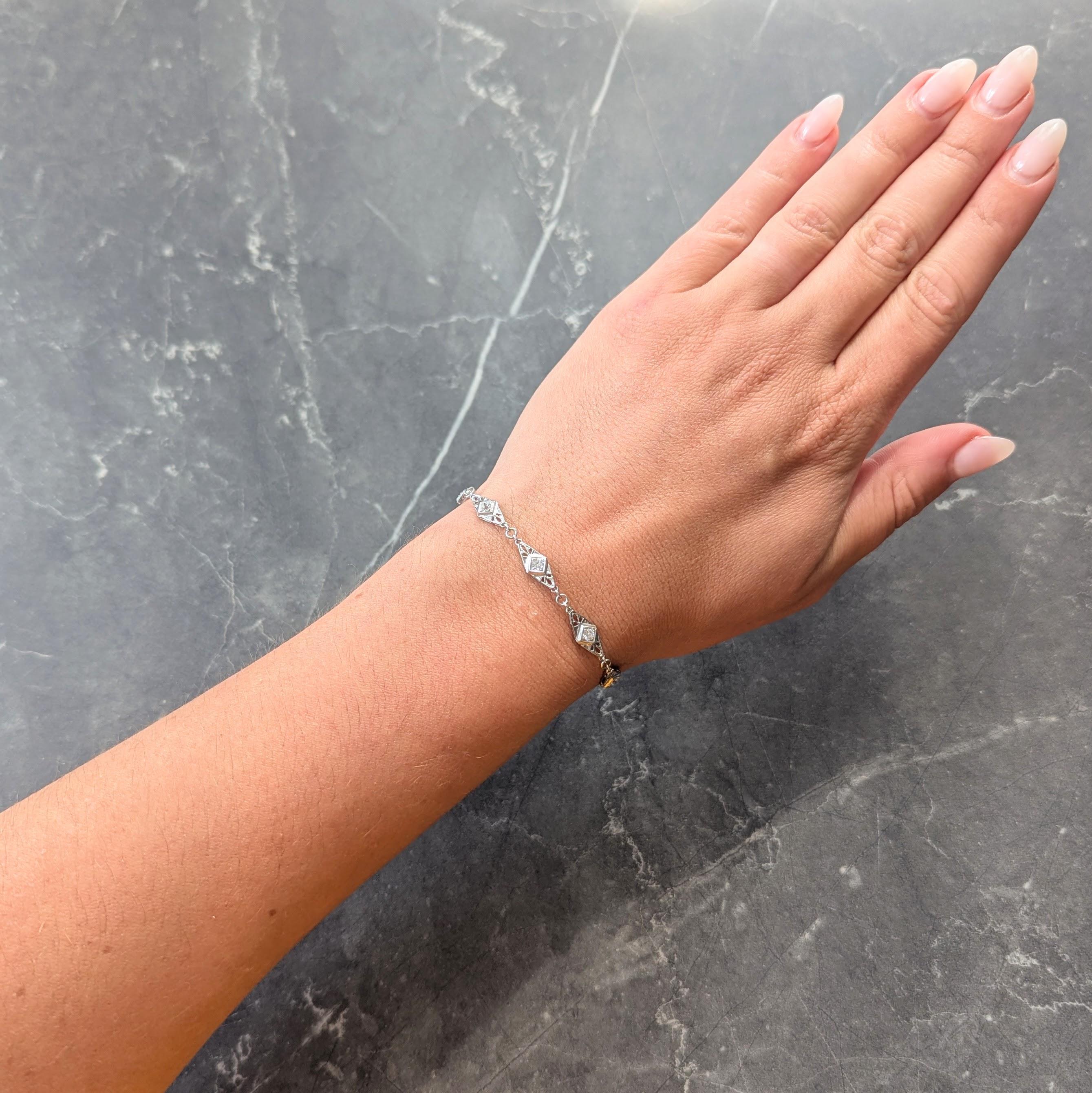 Comprised of fancy navette shaped links each centering old mine cut diamonds
Weighing approximately 0.90 carats total - H/I color with VS2 to SI1 clarity
Bead set in milgrain detail square forms
Flanked by pierced fanning motifs
With pierced
