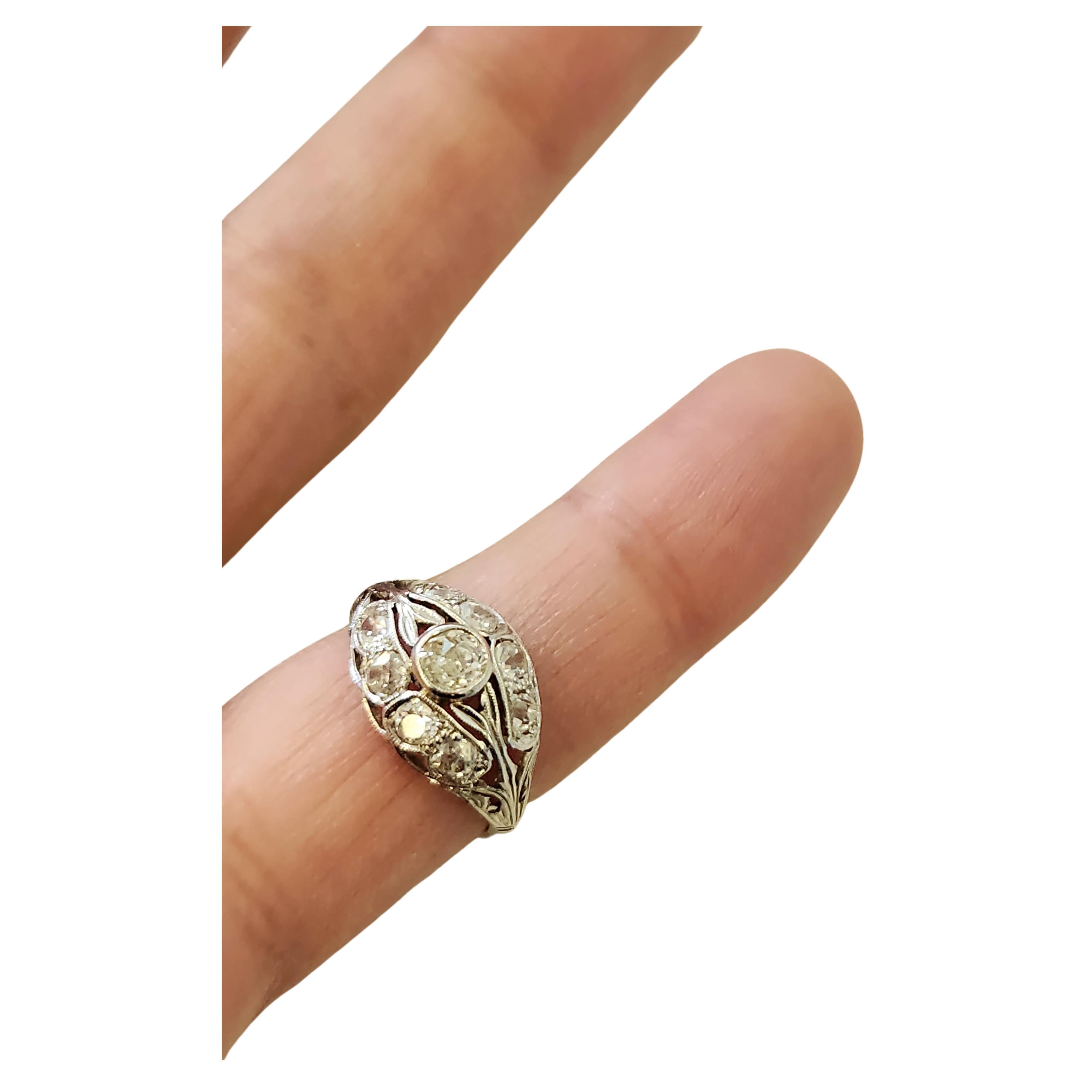 Art deco era white gold ring centered with old mine cut diamond flanked with several old mine cut diamonds with total estimate weight of 1.2 carats in detailed workmanship ring dates back to europe 1920/1925.c