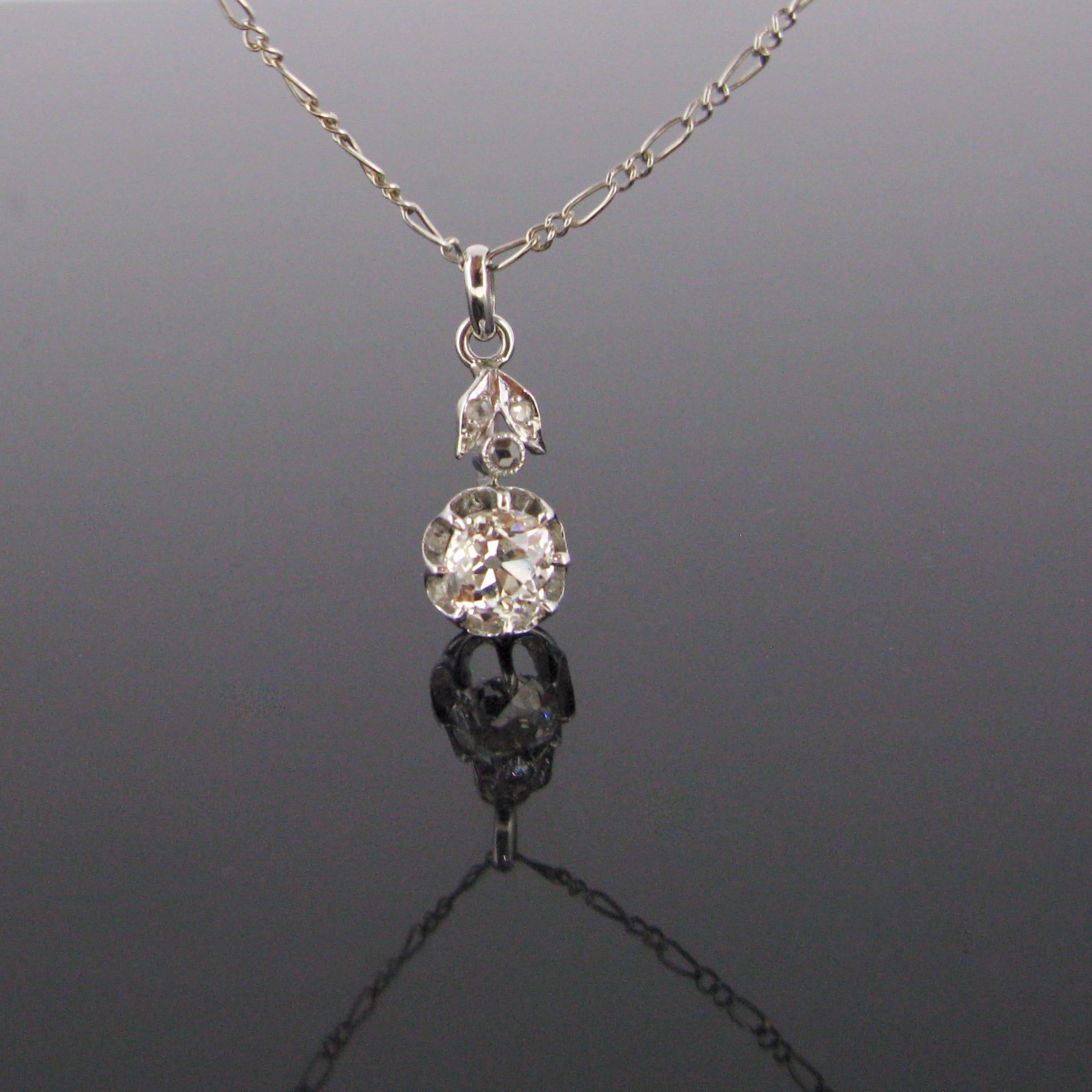 This elegant pendant is from the Art Deco period. It is set with an old mine cut diamond weighing around 1ct. It is topped with rose cut diamonds. The chain is made in 18kt gold and the pendant in platinum (tested). The chain is controlled with the