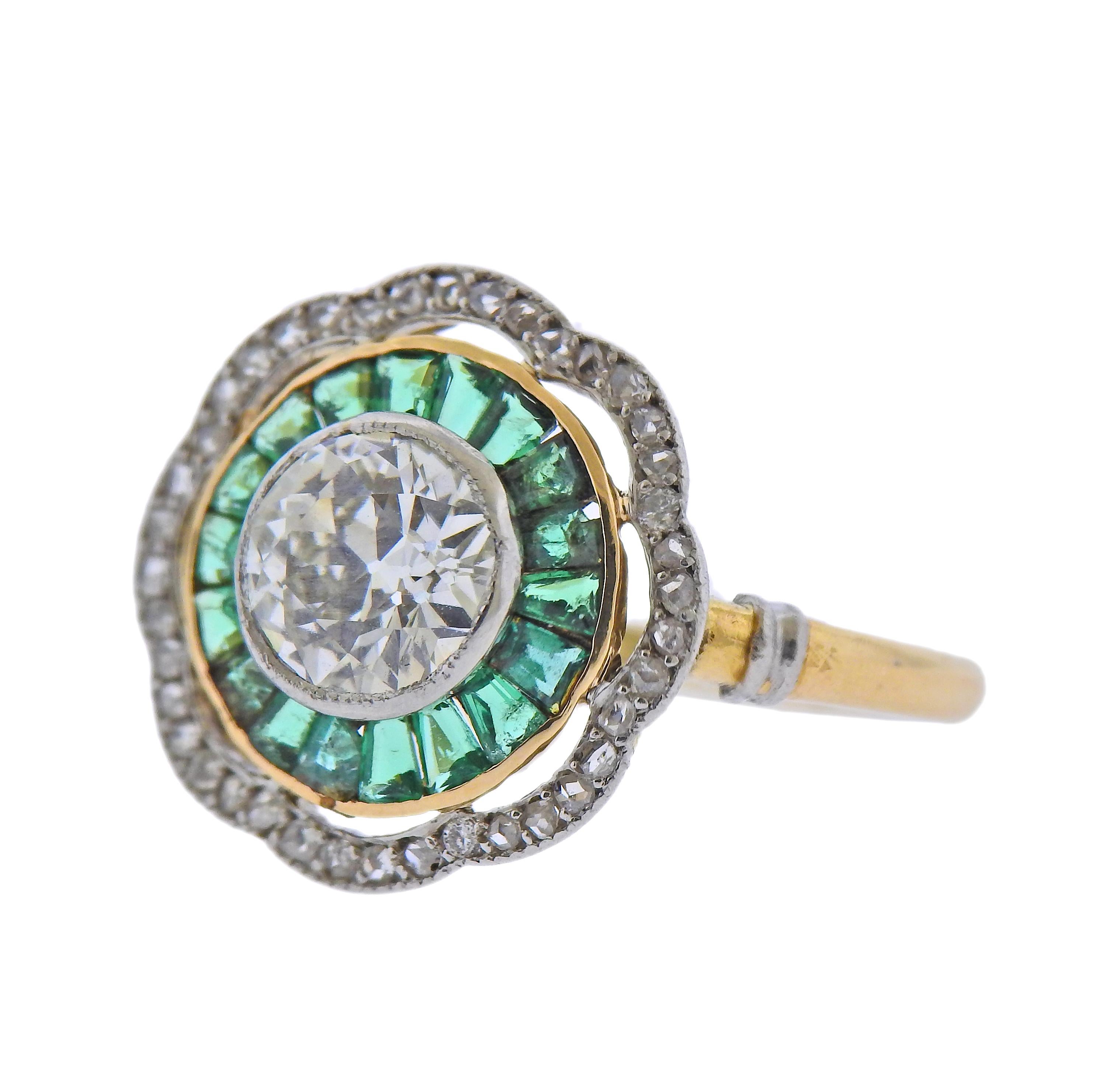 18k gold Art Deco ring, set with emeralds, surrounding a center approx. 1.22ct old mine cut diamond with an open culet, and small surrounding diamonds. Ring size - 6, ring top - 16mm x 16mm. Marked: 22 H 0.  Weight - 4.2 grams. 