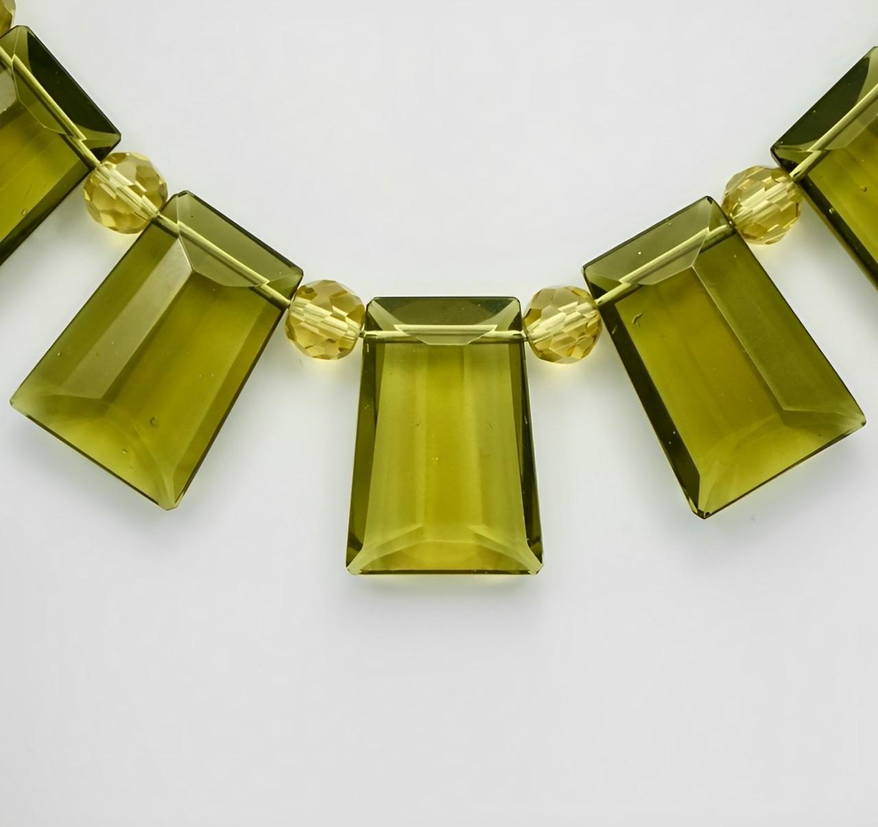 Fabulous Art Deco fringe necklace collar with classic Deco design olive green glass, interspersed with faceted beads which extend to the rest of the necklace. It fastens with a silver tone barrel clasp. The beads are strung on to wire.

The necklace