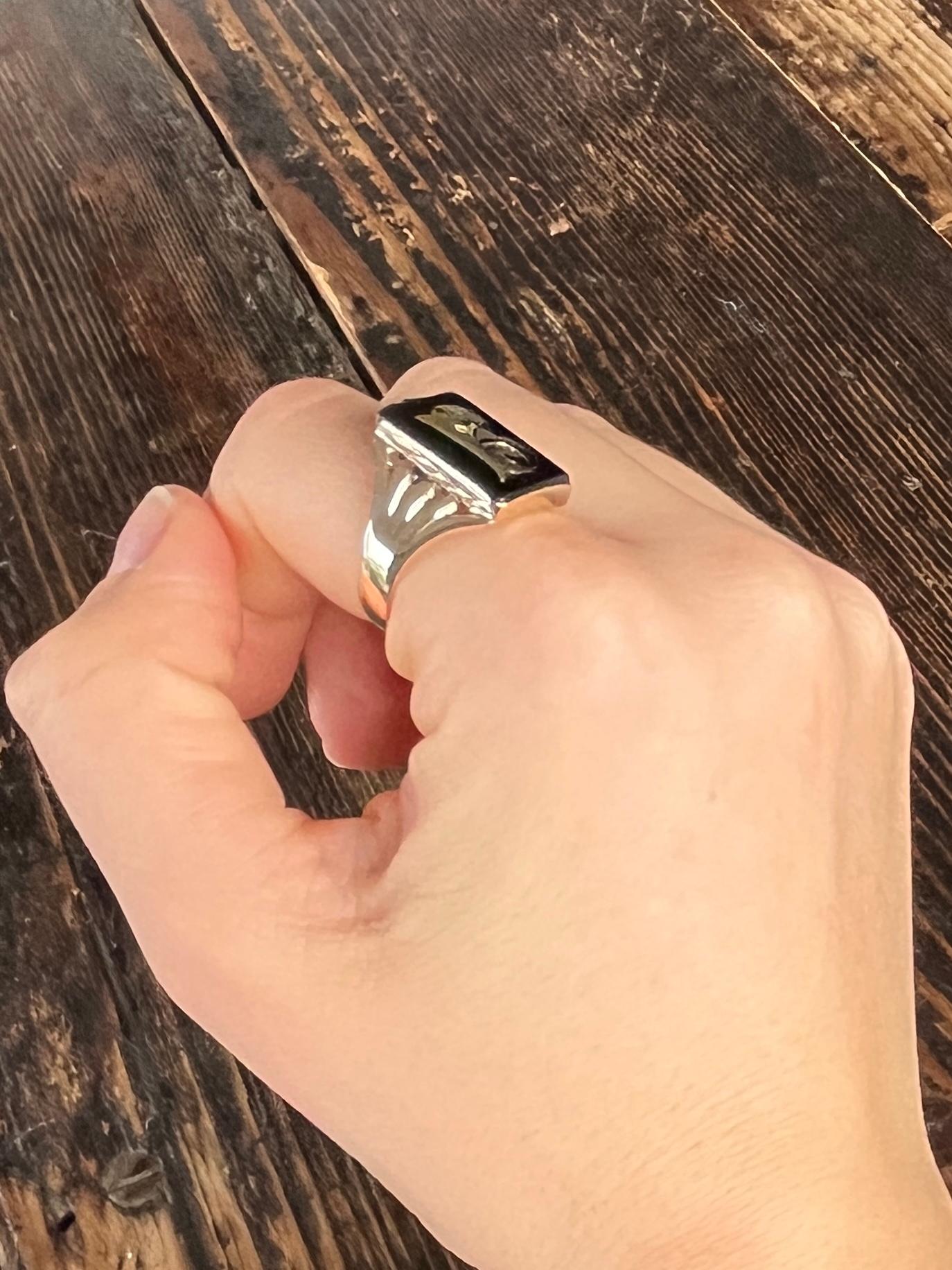 Dieser Ring enthält einen rechteckigen Onyxstein mit dem Buchstaben 