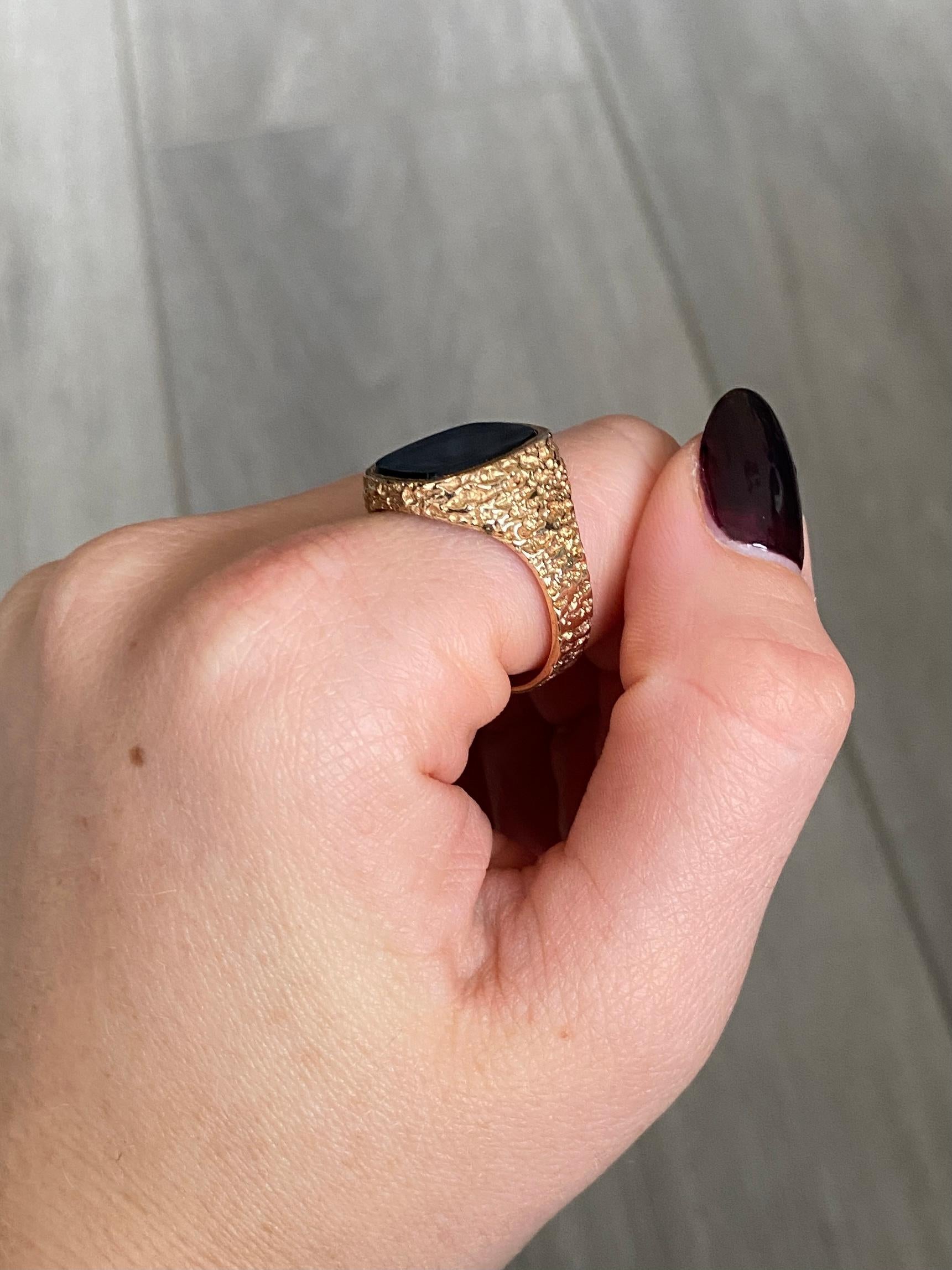 The onyx in this signet ring is in lovely condition and it so glossy! The stone is set within textured 9ct gold chunky band. Hallmarked Birmingham 1971.

Ring Size: U 1/2 or 10 1/4 
Stone Dimensions: 14x12mm 

Weight: 6.1g