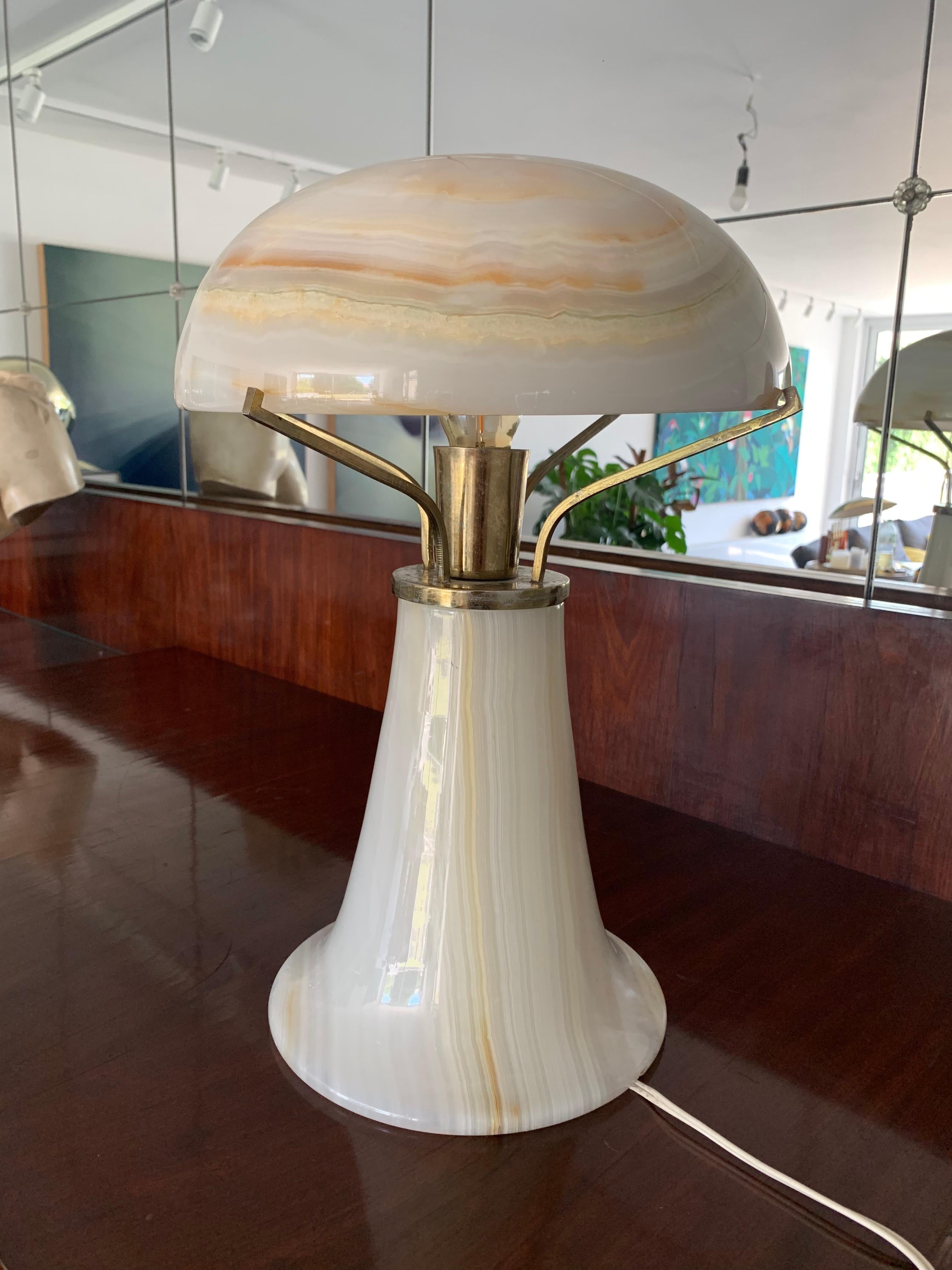 This is an original Art Deco table light that gives off soft light.
It’s made entirely out of onyx - when the light is turned on it shines softly through the stone,
Creating a beautiful lighting effect.