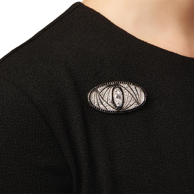 Broche Art Déco de diamantes, ónice y esmalte, Francia
El broche, de forma ovalada, está engastado con diamantes europeos antiguos, de mina antigua y talla única, realzados con líneas de esmalte negro, enmarcados por ónice talla calibré, numerado