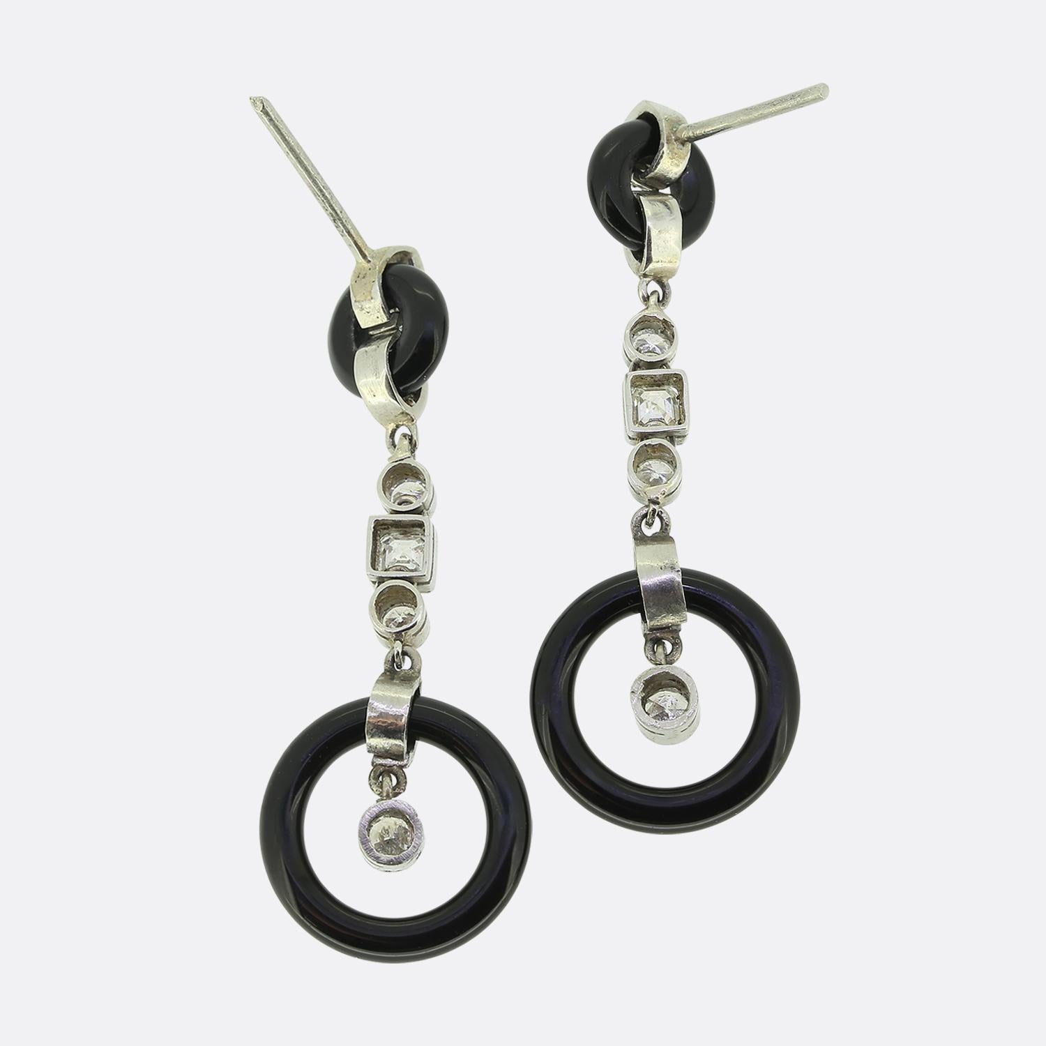 Ecco un elegante paio di orecchini a goccia tratti dal movimento Art Déco. Questi orecchini presentano una serie di scintillanti diacanti singoli e a taglio asscher incastonati in un'elegante struttura metallica. Ogni pezzo è impreziosito da un