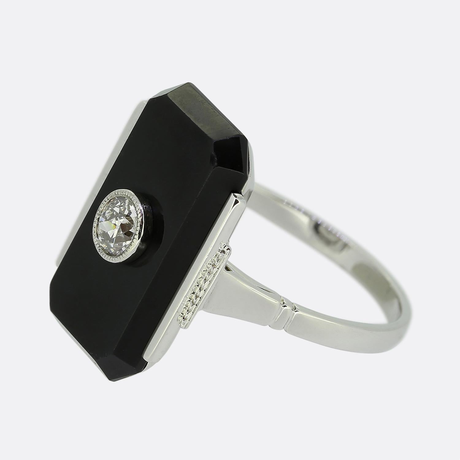 Here we have a classically styled plaque ring crafted during the pinnacle of the Art Deco movement. This 14ct white gold piece features a single round faceted old European cut diamond in a fine milgrain setting. This focal stone sits slightly risen