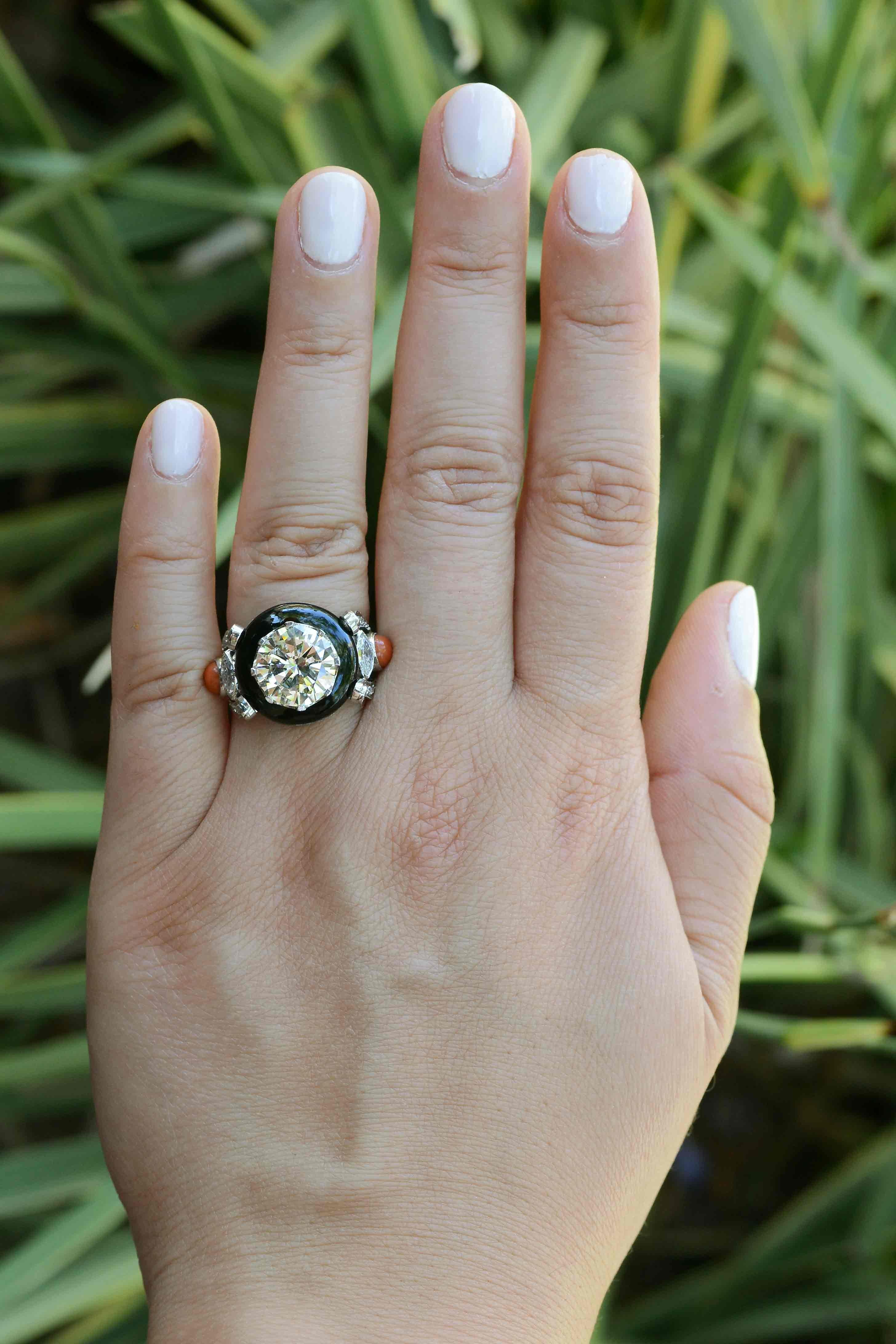 The Sheryl coral, black onyx and diamond engagement ring is a most intriguing, authentic Art Deco masterpiece. Centered by a scintillating and large 3.58 carat round diamond that lights up the room. Making this cocktail ring even more impressive is