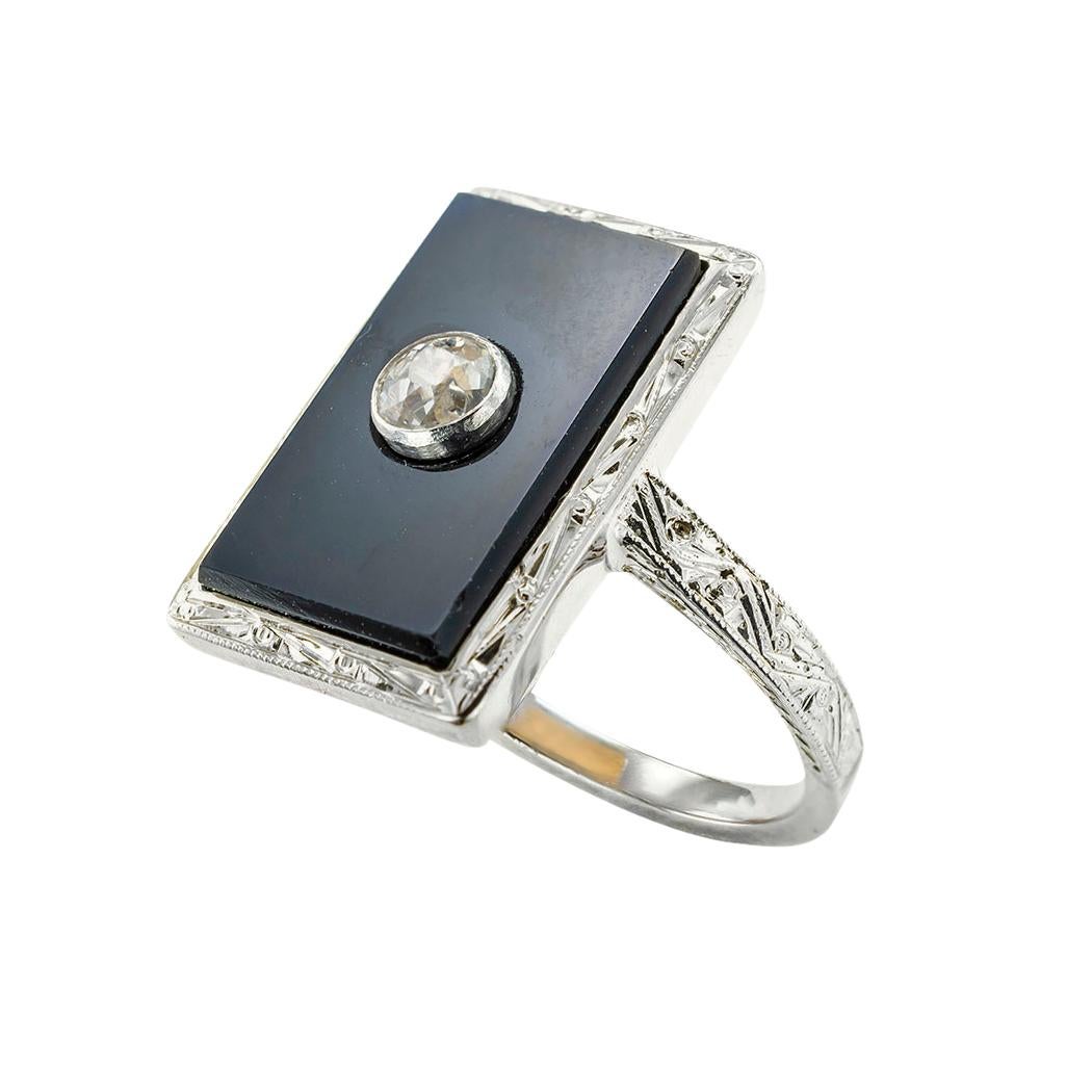 Art Deco onyx diamond and gold ring circa 1925. *

ABOUT THIS ITEM:  Art Deco jewelry design encompasses many styles.  In this ring, bold geometric lines are accented by the dominant black onyx rectangular plaque centering upon a bezel-set old