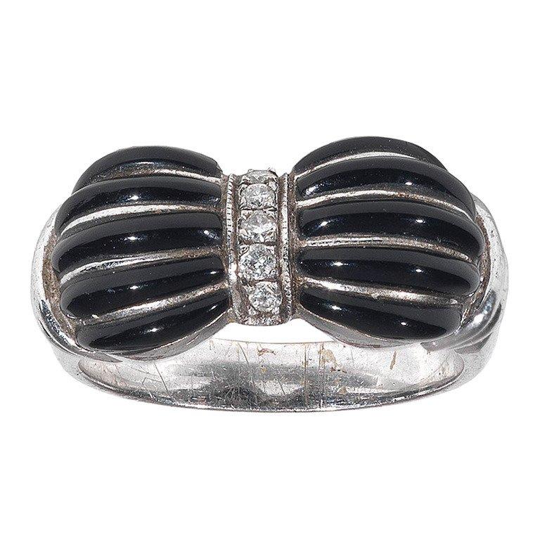 
Centering old mine-cut diamonds to scalloped shaped black onyx sides, mounted in platinum, circa 1920

Size 7