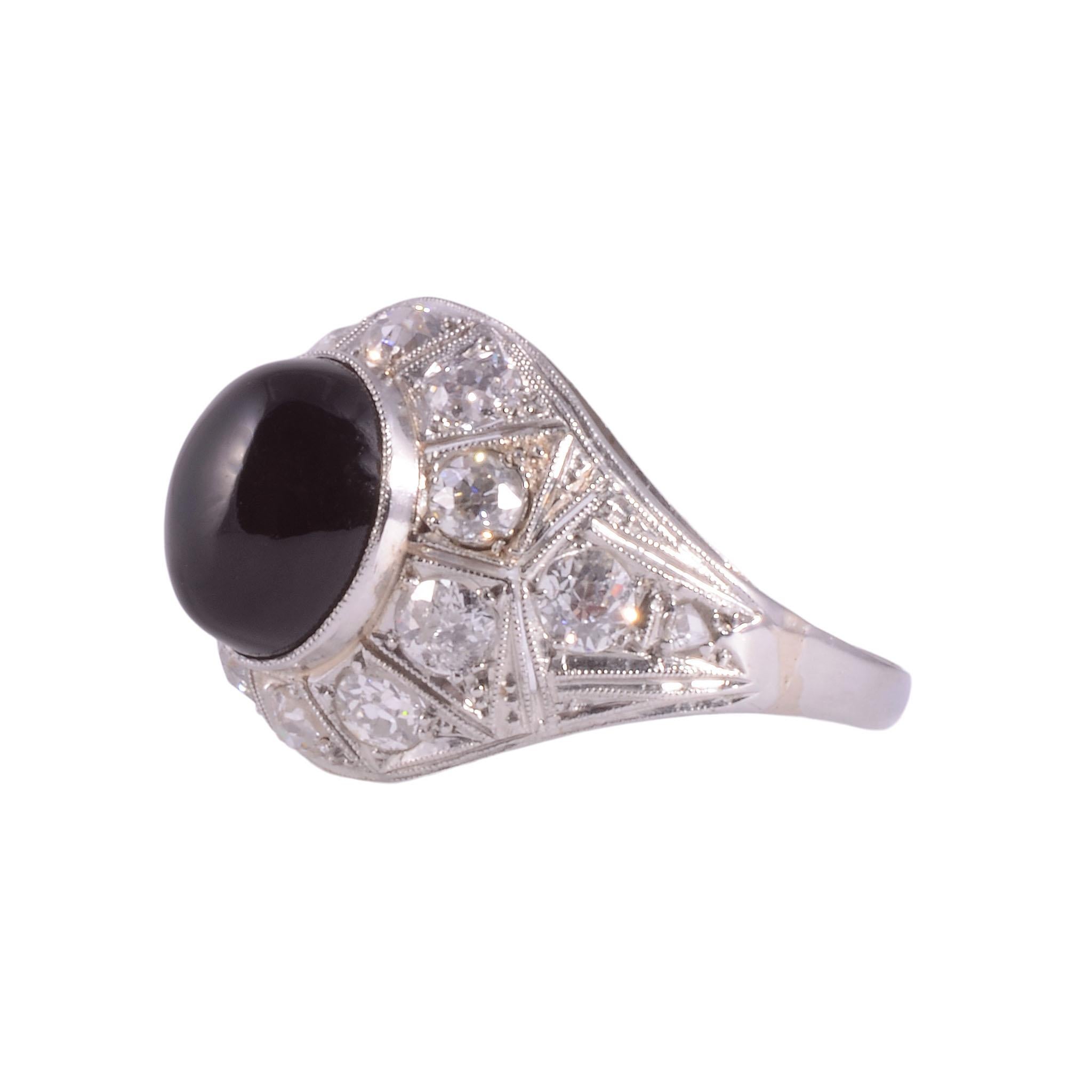 Vintage Art Deco Onyx & Diamant Platinring, um 1935. Dieser Art-Déco-Ring hat einen Onyx-Cabochon in der Mitte, der 10,40 mm x 8,85 mm x 5,53 mm misst. Der Onyx ist mit 13 Diamanten mit einem Gesamtgewicht von 1,12 Karat verziert, darunter acht alte