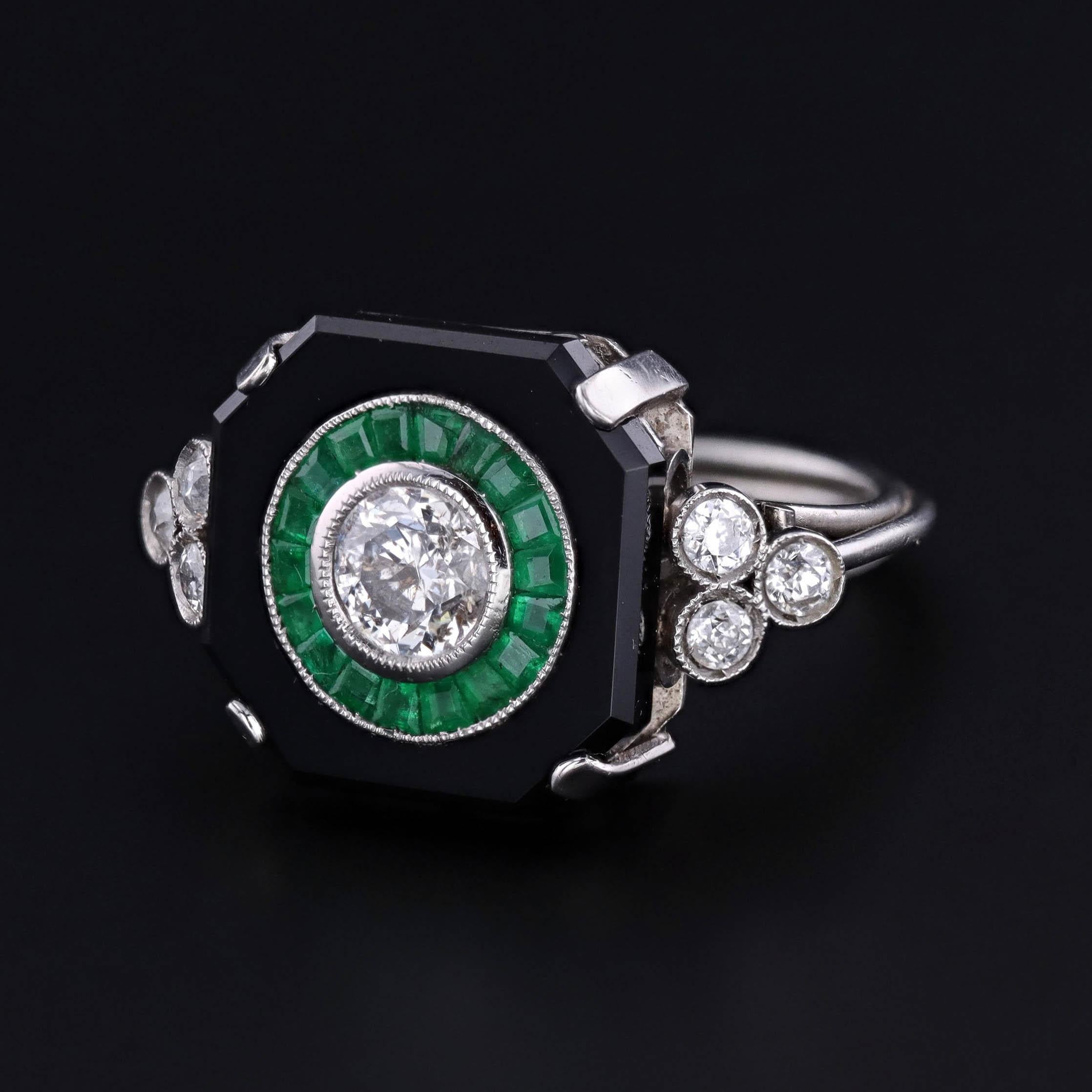 Anello Art Deco (anni '20 circa) con un diamante di taglio transitorio di 0,92 carati, incastonato in un'aureola di smeraldi, montato in onice nera con sei diamanti d'accento sulle spalle, il tutto incastonato in una montatura in platino/palladio.