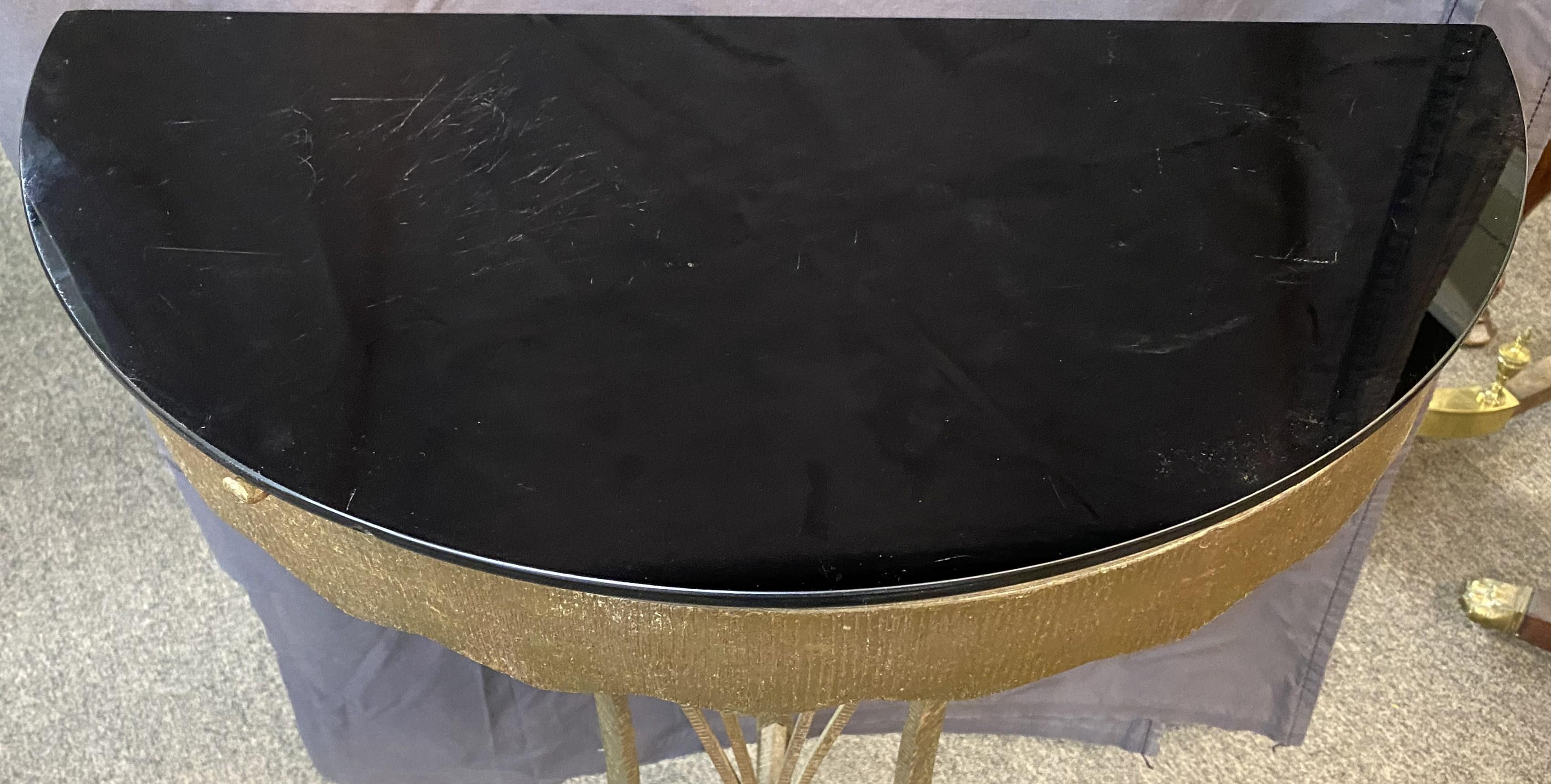 A fine form Art Deco onyx glass top demi line gilt iron console, in the manner of Oscar Bach, dating to the early 20th century, in very good condition, with some glass surface scratches, minor edge imperfections, and wear commensurate with age and