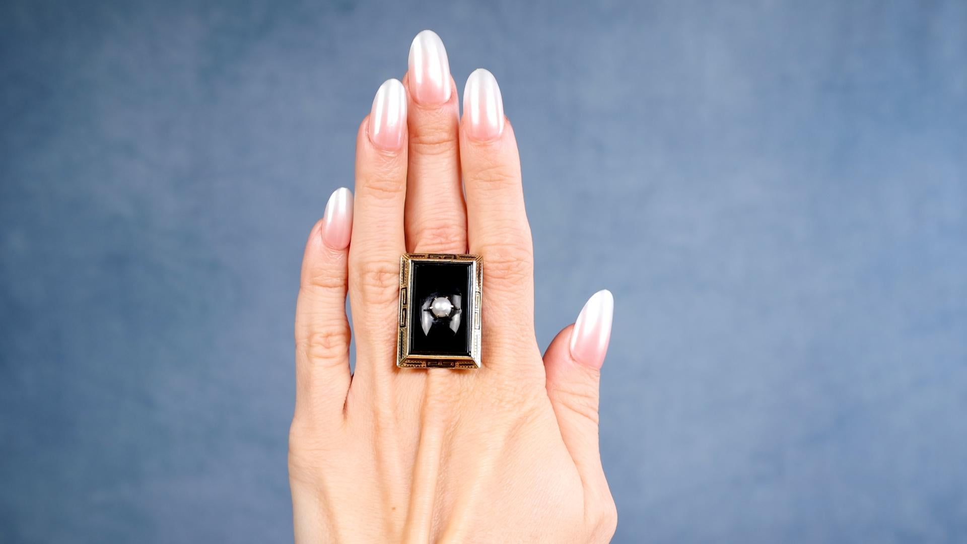 Ein Art Deco Onyx Perle 14k Gelbgold Ring. Ausgestattet mit einem Stück poliertem Onyx und einer weißen Perle von 5,10 Millimetern. Gefertigt aus 14 Karat Gelbgold mit Feingehaltsangabe. Ca. 1920. Der Ring hat die Größe 6 ¾ und kann in der Größe