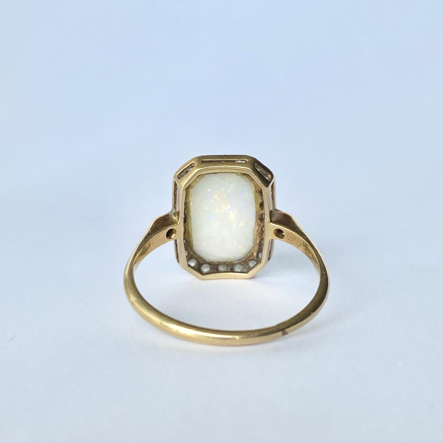 This gorgeous ring has a pale yet colourful opal at the centre of a halo of diamonds. The stones are set in platinum an the rest of the ring is modelled in 18ct gold. 

Ring Size: Q 1/2 or 8 1/4
Panel Dimensions: 16x6mm

Weight: 3.3g