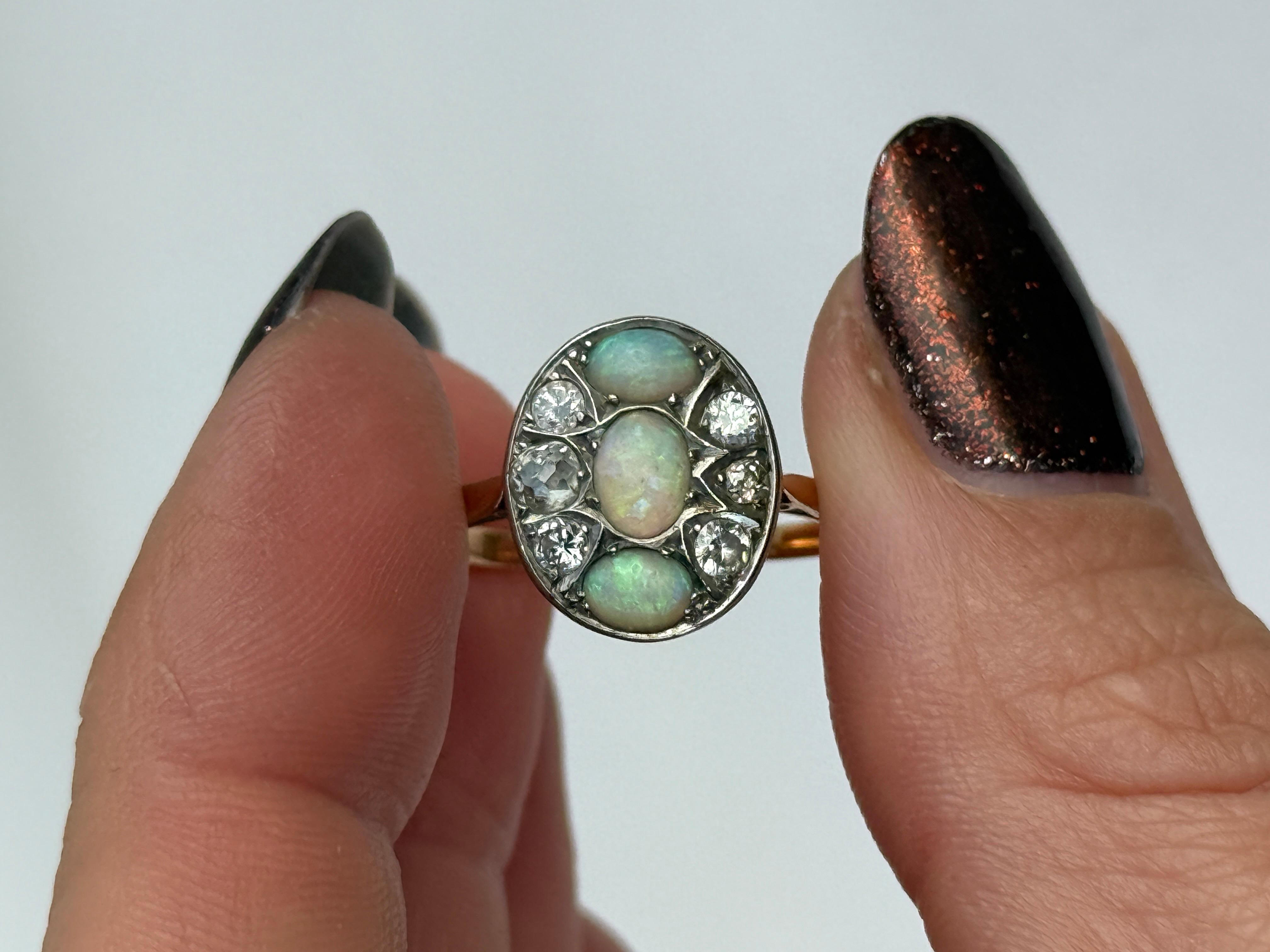 L'opale è di colore pallido e presenta molti lampi di colore.  verde e tutti gli altri colori al suo interno. I diamanti antichi tagliati in miniera che circondano gli opali hanno un valore totale di 42pt. L'anello è realizzato in oro 18 carati e le