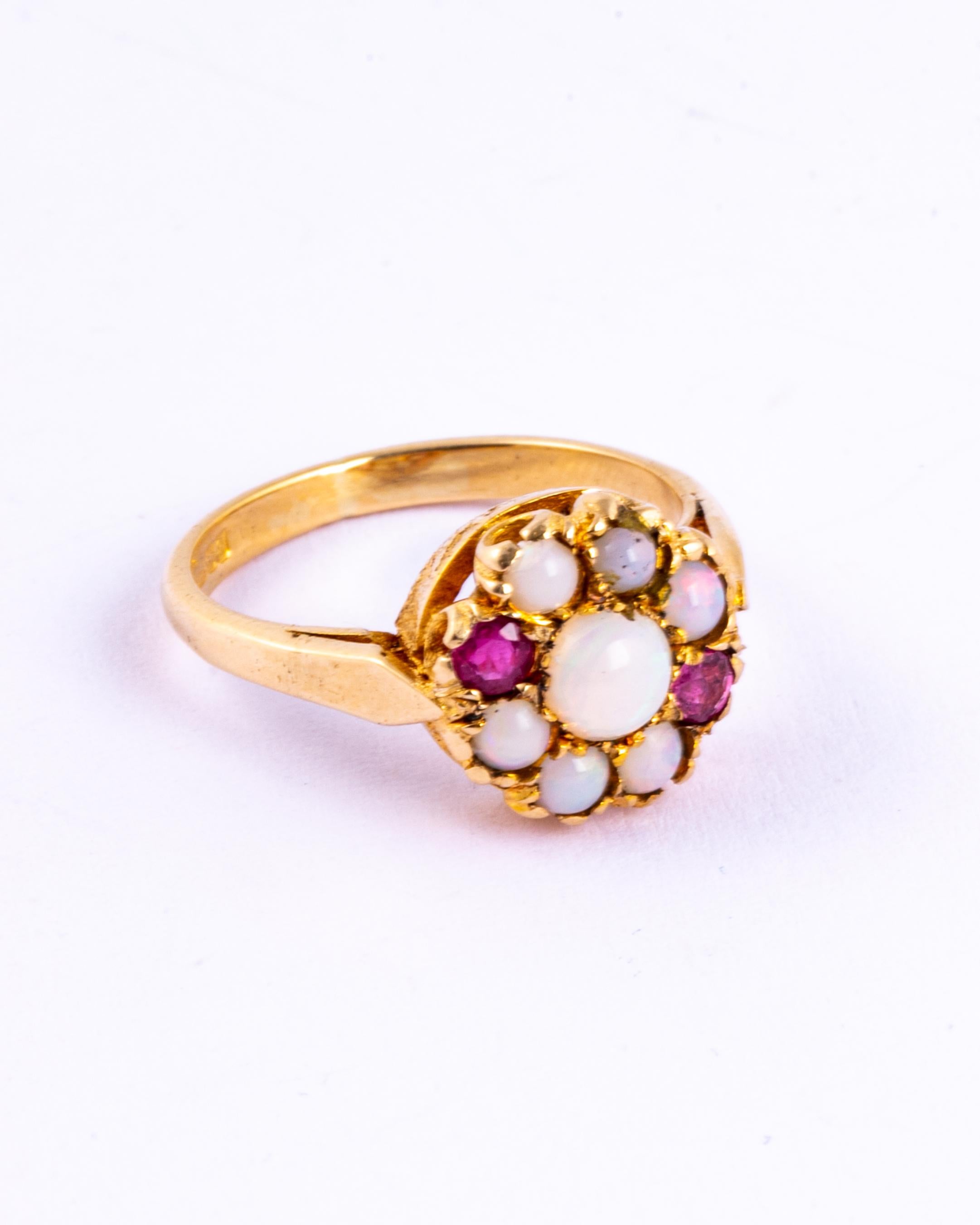 This sweet cluster ring holds a total of 7 colourful opals and two rubies. The rubies measure 10pts each and the opal total approximately 90pts. The ring is modelled in 9ct gold and made in Birmingham, England. 

Ring Size: K or 5 1/4
Cluster