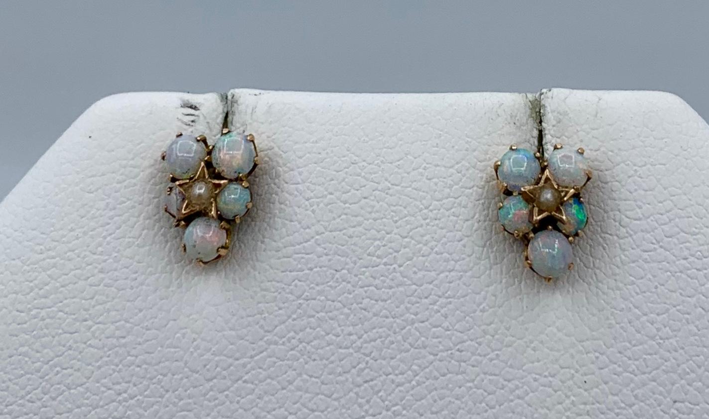 This is a beautiful romantic pair of antique Art Deco Opal Pearl Earrings with 10 spectacular round Opal cabochons of great beauty accented by a pearl set in a star motif setting in 14 Karat Gold.  The colors in these Opals are absolutely stunning