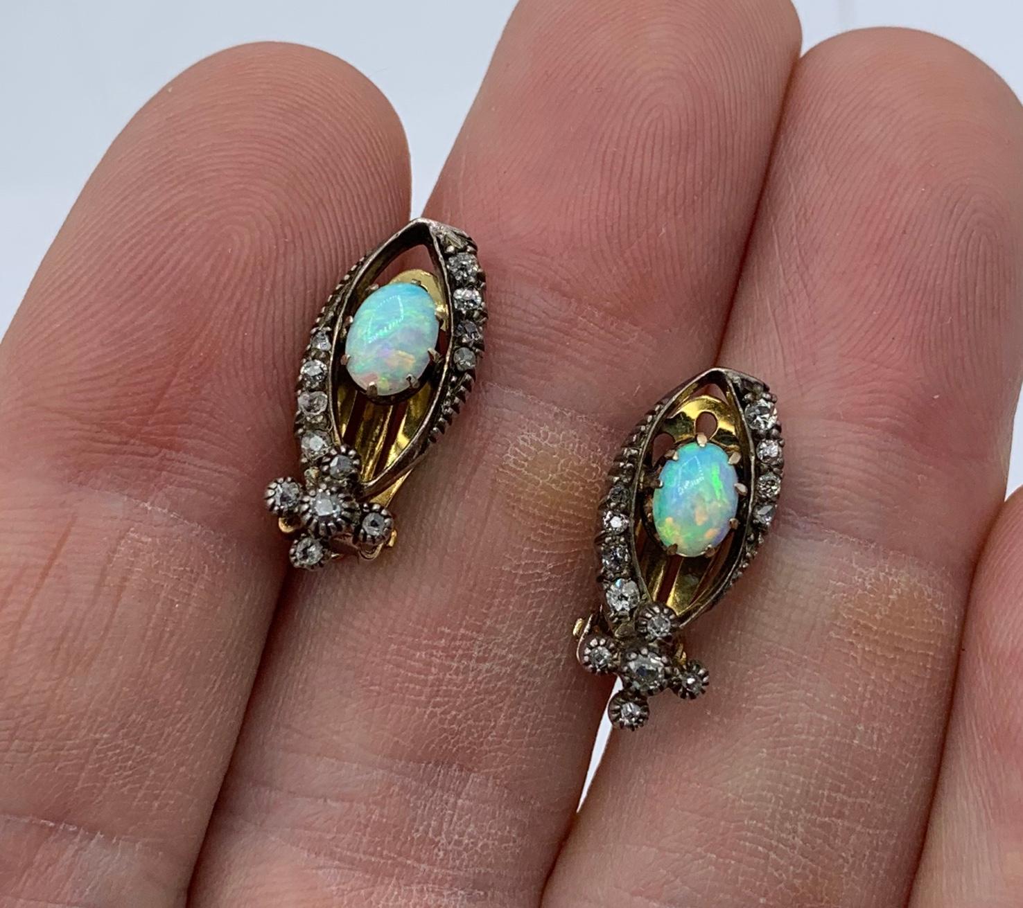 This is a gorgeous pair of antique Art Deco Opal Diamond Earrings with spectacular oval Opal cabochons of great beauty accented by sparkling white Old Mine Cut and Rose Cut Diamonds and set in 14 Karat Gold.  The colors in these Opals are absolutely