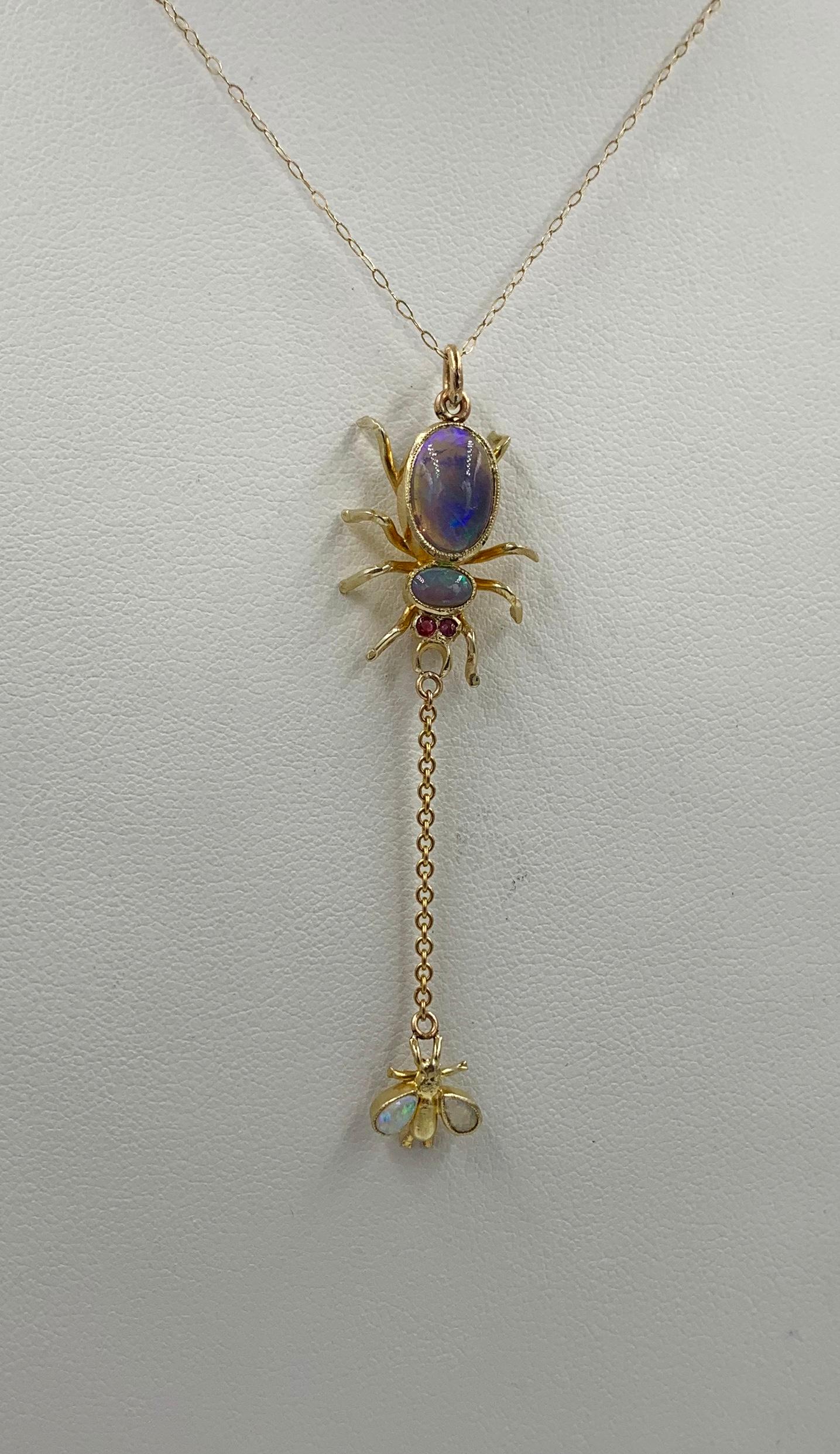 A stunning and rare antique Art Deco Spider and Fly Pendant set with gorgeous Opal gems and Ruby eyes in 10 Karat Gold.  The extraordinary pendant has the most fabulous Opals.  The spider is set with two oval opal gems in the body and with two round