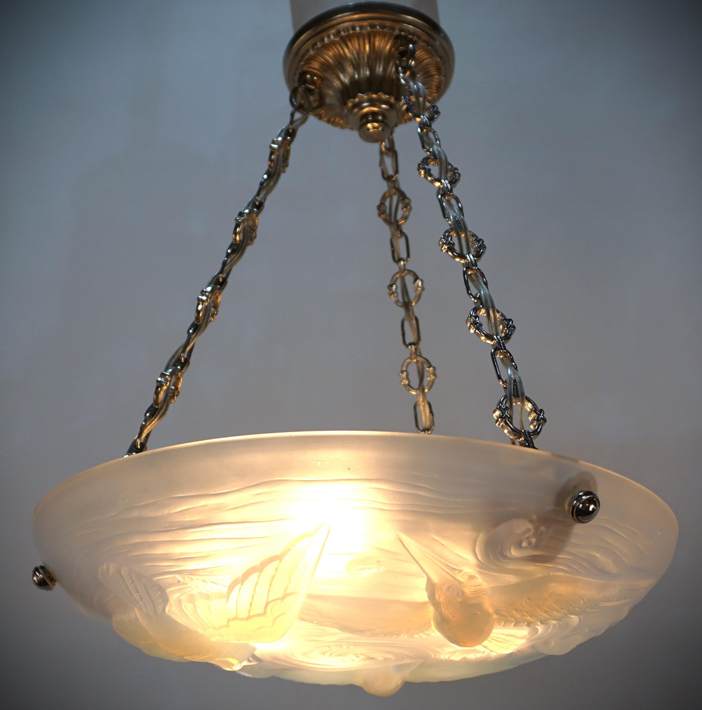 A wonderful Art Deco chandelier. This elegant clear frost complacent, light honey blue color frost glass chandelier features a beautiful flying bird and fish design with nickel on bronze hardware.
Professionally rewired and ready for installation.