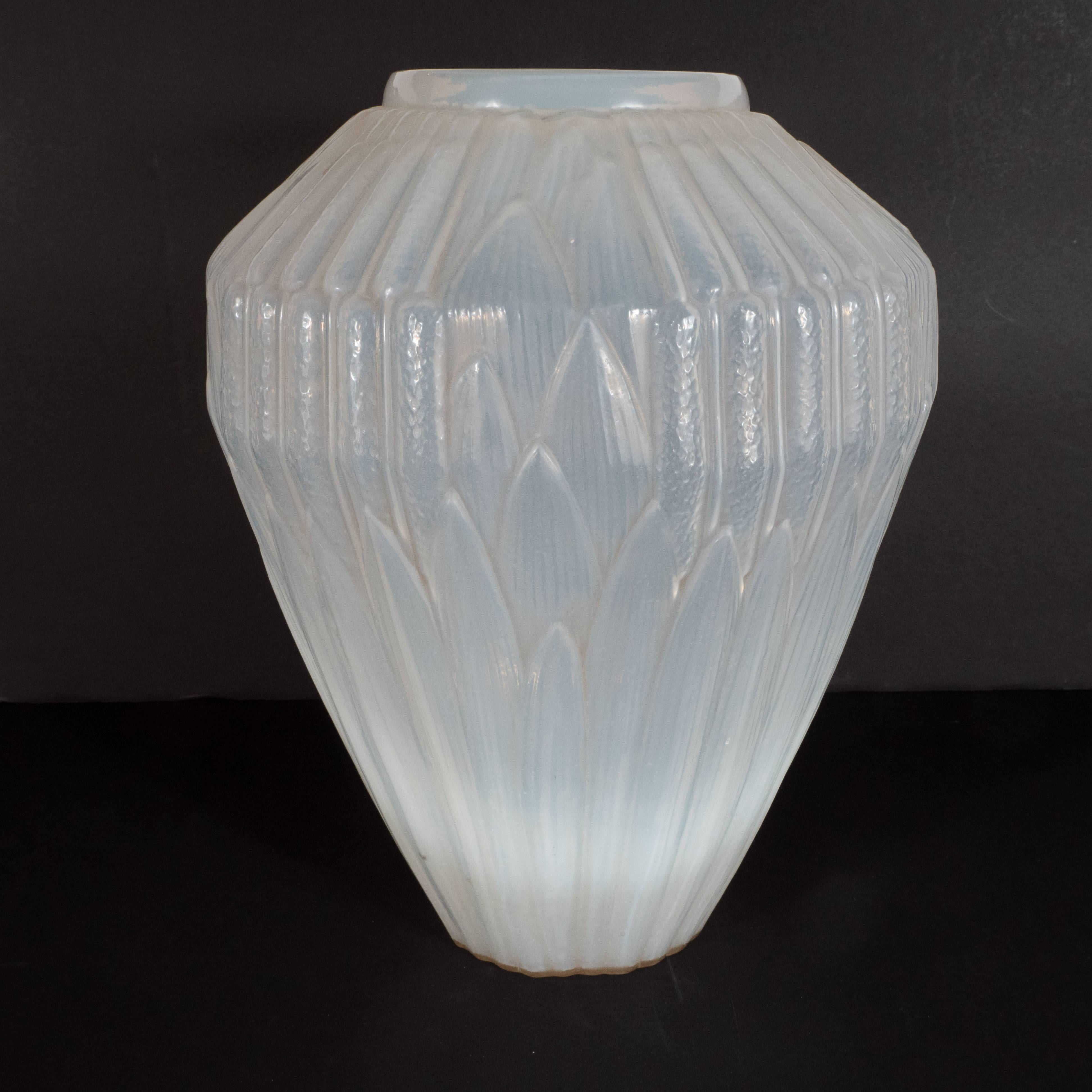 This impressive and dramatic vase was realized by the illustrious Parisian glass blowing atelier, Andre Hunabelle, circa 1930. Realized in opalescent glass with a subtle iridescence and opacity, this piece offers a wealth of geometric patterns in