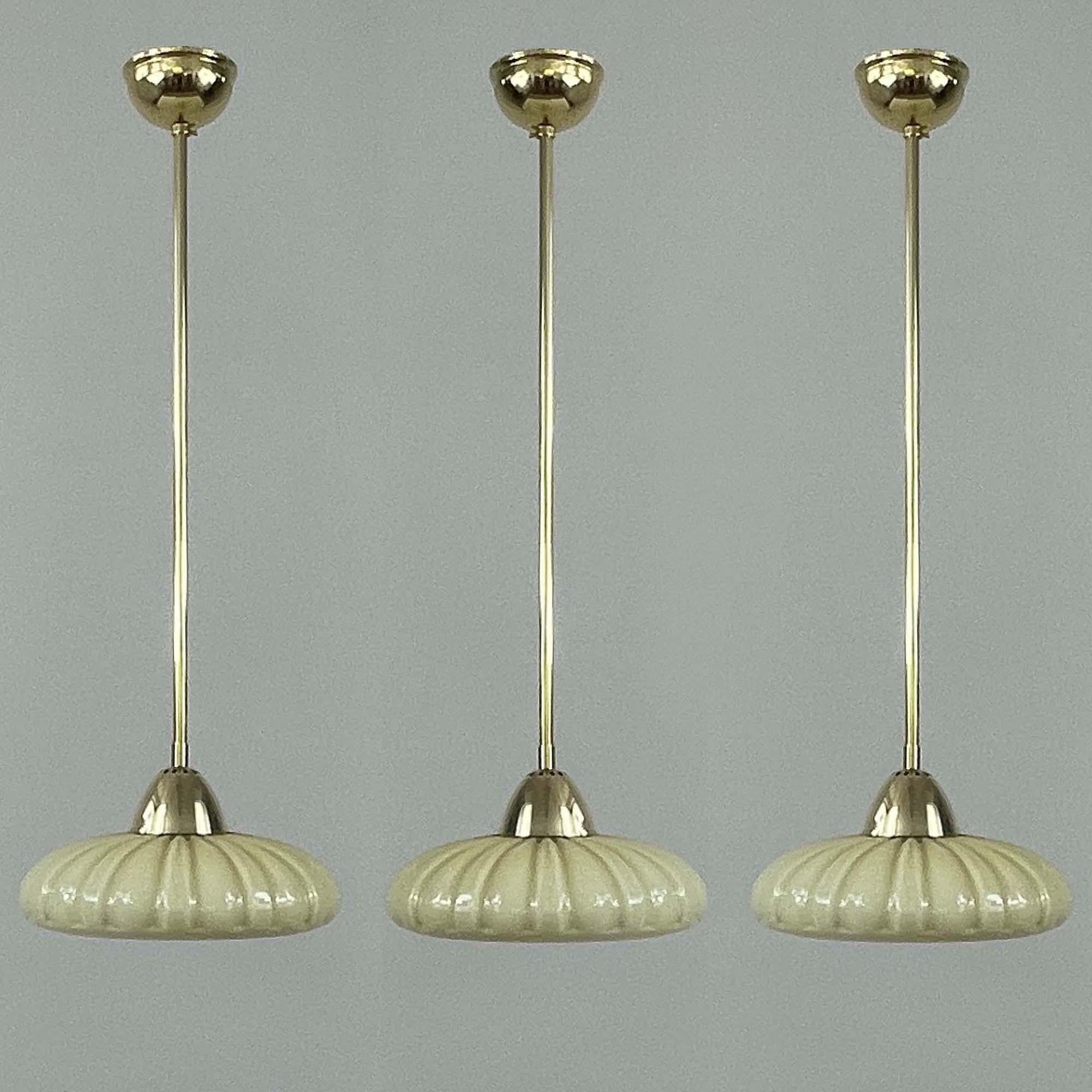 This minimalist pendant was designed and manufactured in Sweden in the 1940s. 

The pendant features a sleek and streamlined design typical of the Art Deco style, emphasizing geometric forms and modern elegance. The light's shade has a fluted,