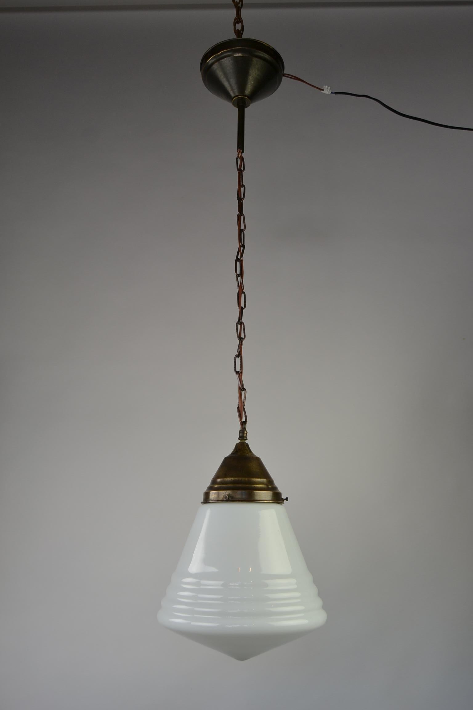 Art-Deco-Hängeleuchte mit weißem Opalglasschirm. 
Der Glasschirm ist kegelförmig und flach. 
Diese Art-Deco-Leuchte an einer Kette stammt aus den 1940er Jahren. 
Die Kette ist ersetzt worden. 

Maße: Gesamtlänge 41,33 Zoll oder 105 cm