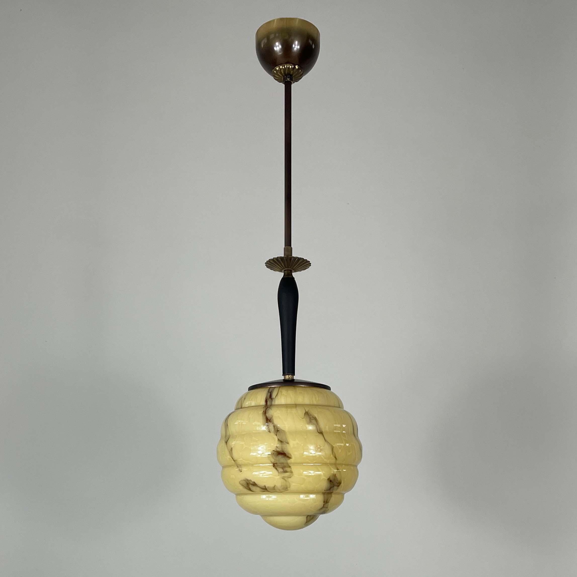 This beautiful pendant was designed and manufactured in Sweden in the 1930s during the Swedish Grace era.

The pendant features a marbled glass shade, shaped in a beehive / ribbed form, with a warm beige or cream base color and dark brown streaks