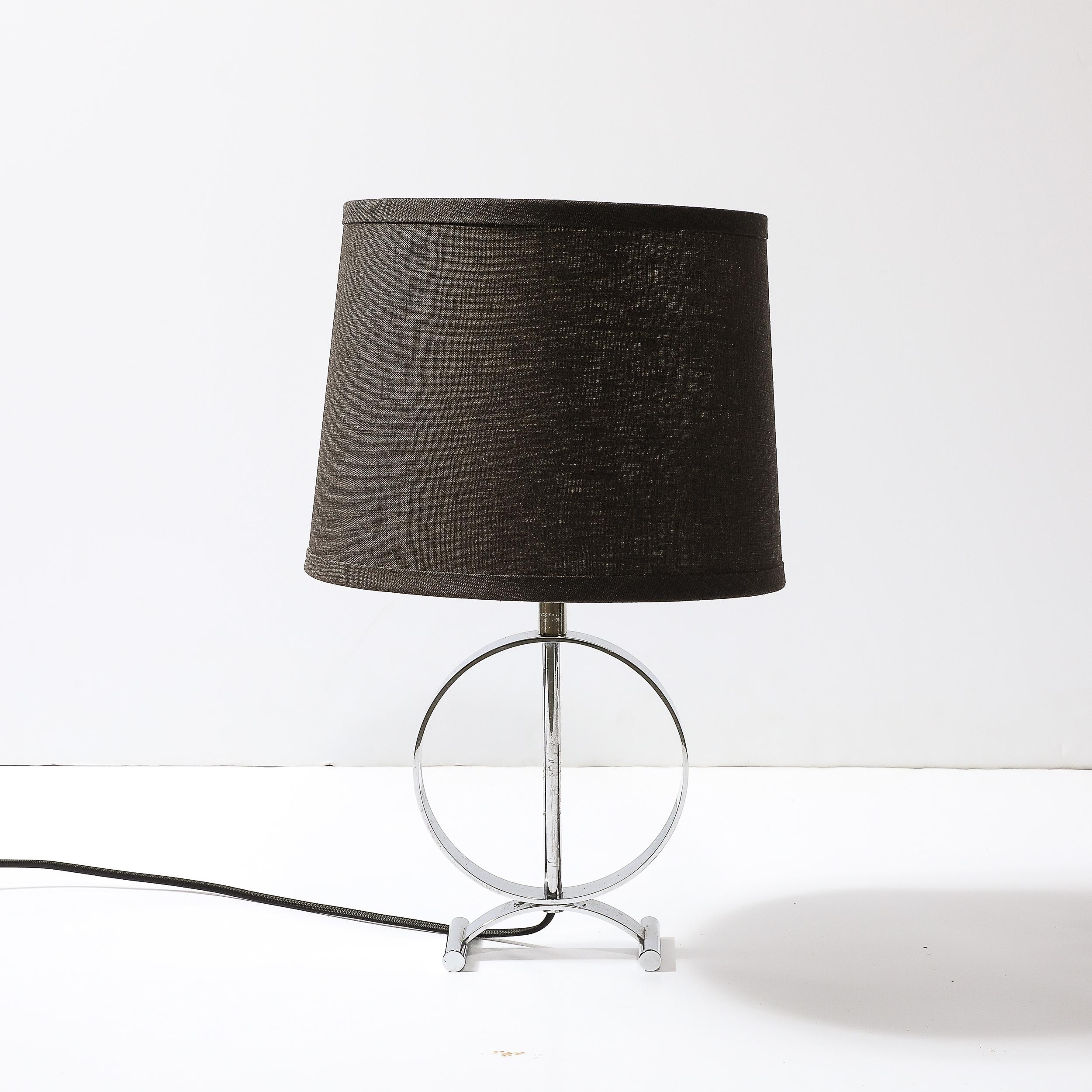 This elegant and minimal Art Deco Open Form Machine Age Table Lamp in Chrome originates from the United States, Circa 1935. This table lamp features an open form body with a chrome rod in the center, a circular chrome band, and two cylinders