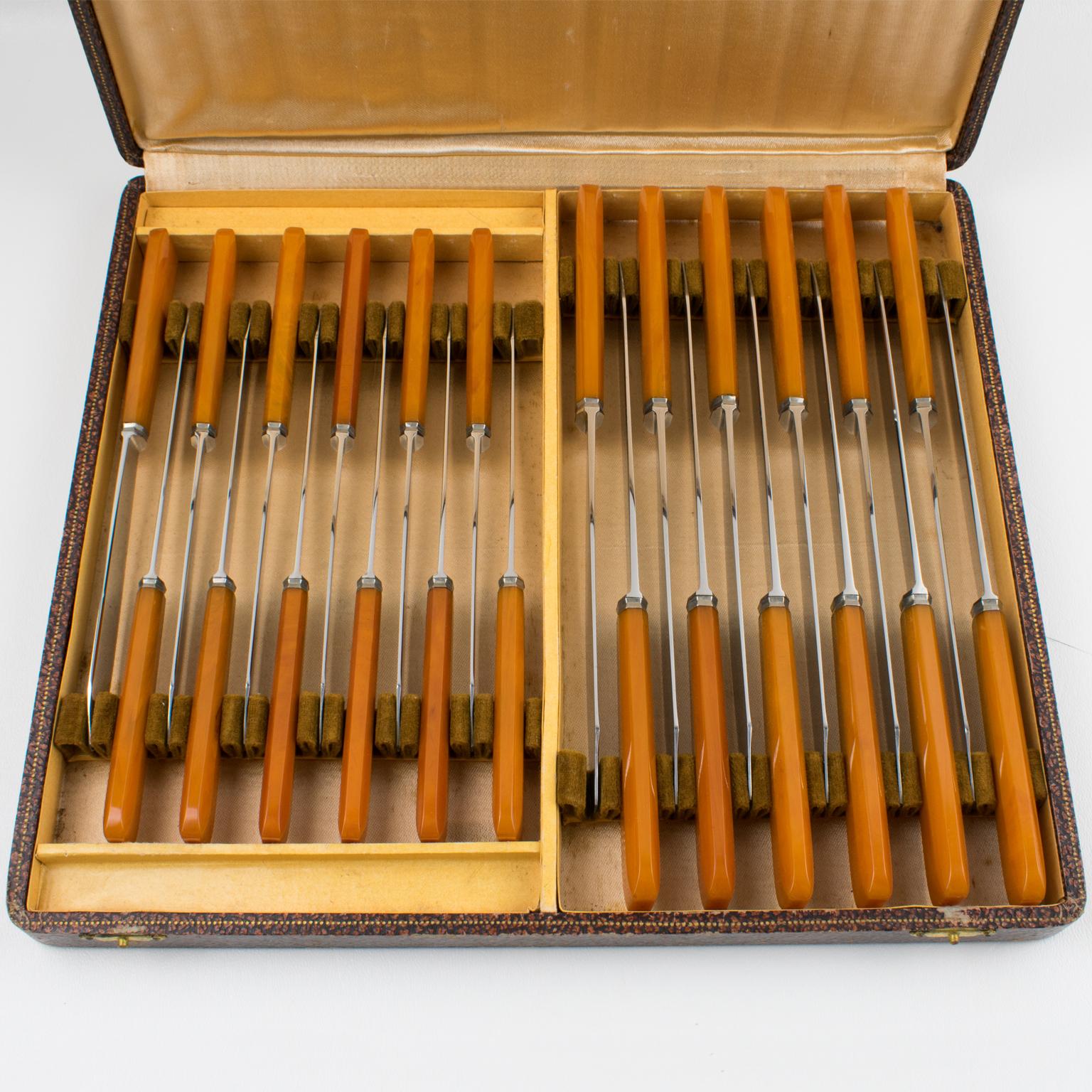 This elegant French Art Deco Bakelite and stainless steel knife set is still in its original box. The two ensembles consist of 12 pieces each, specifically designed for meat and fruit/cheese. The pieces feature stainless Steel blades (in French