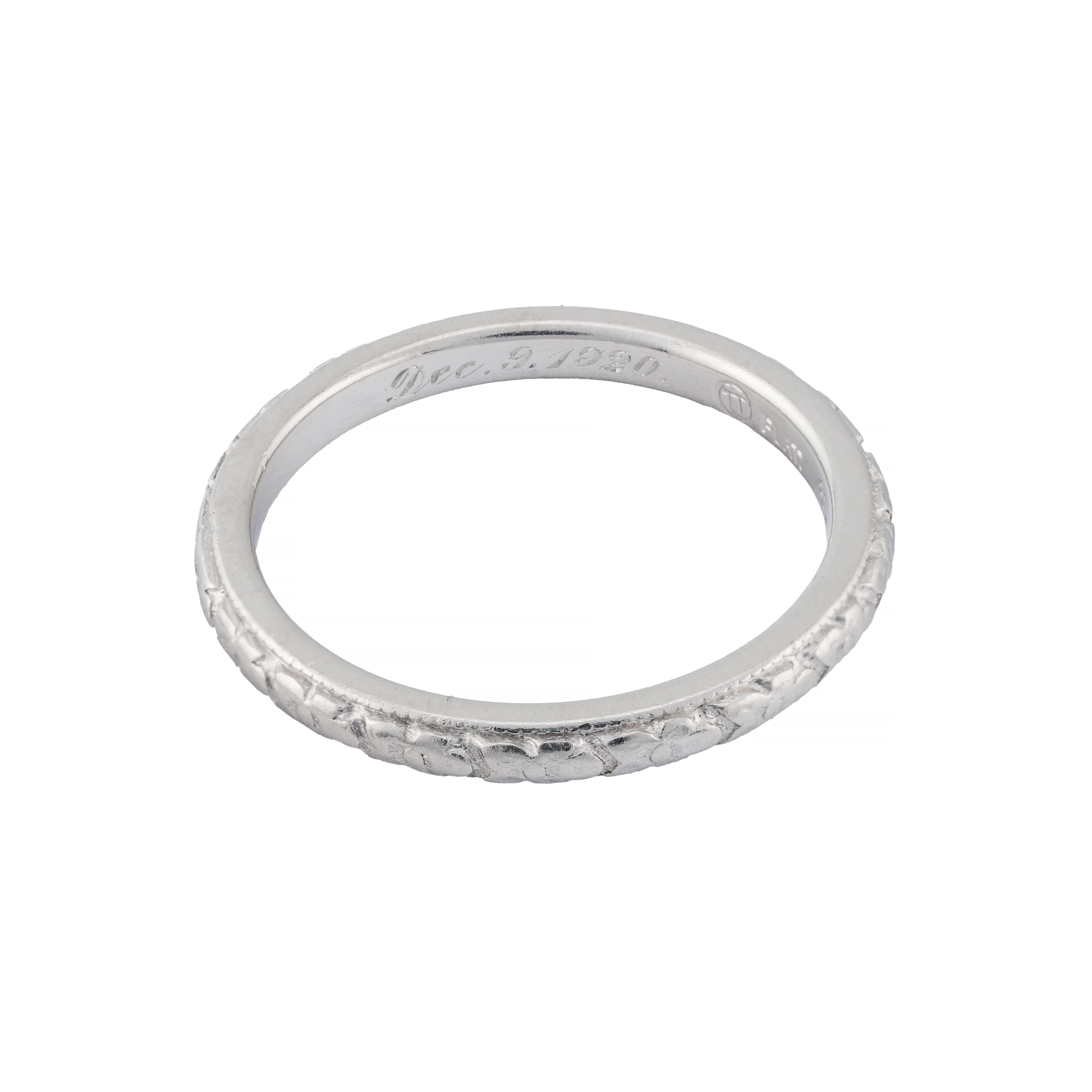 Aston Estate Jewelry presenta:

Una squisita fede nuziale Art Deco realizzata in lussuoso platino. Il cinturino presenta intricate incisioni floreali con il motivo dell'Orange Blossom, che mette in mostra la meticolosa maestria degli anni '20. Con