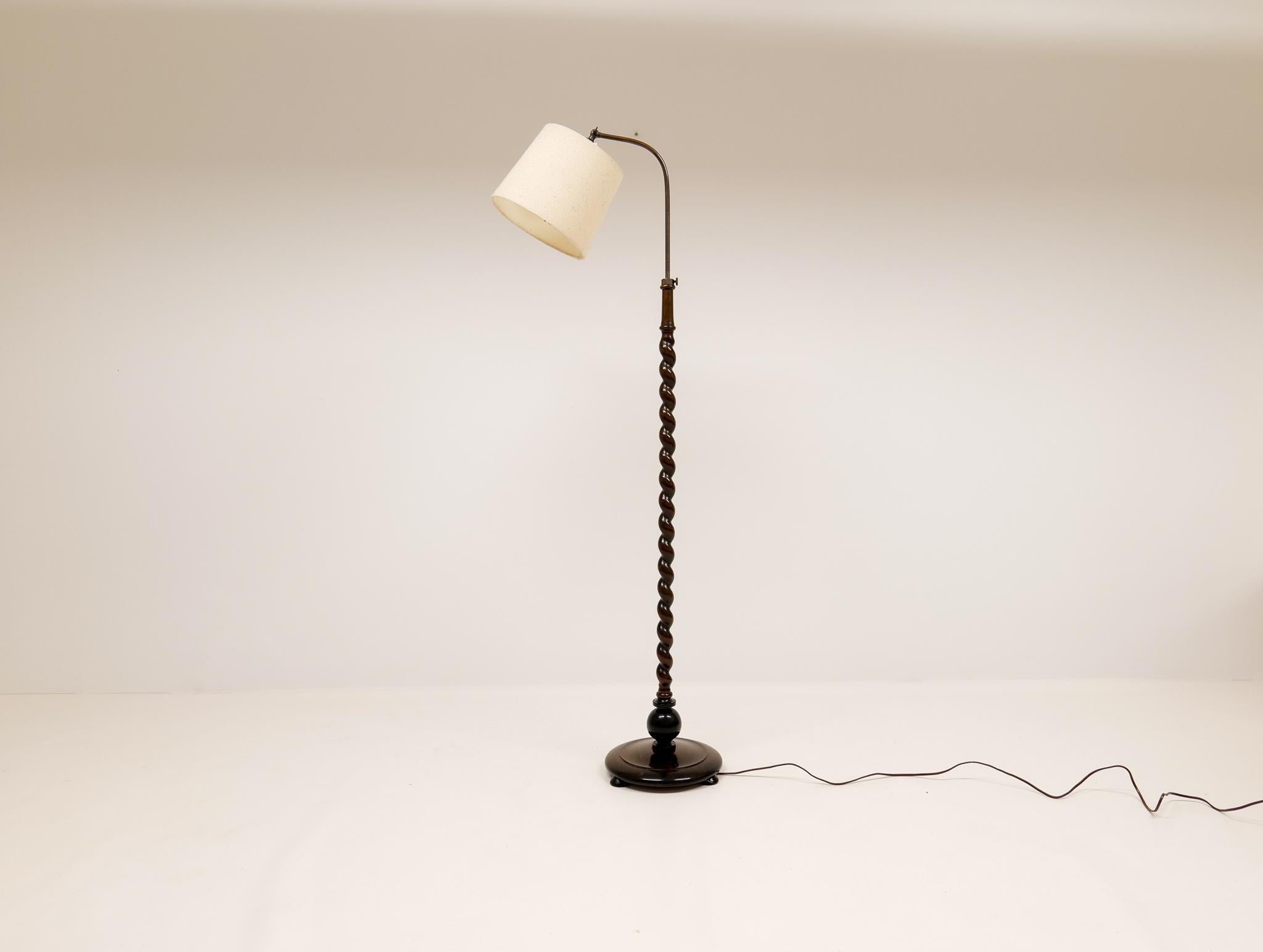Schön aussehende organische Stehlampe mit einem Sockel und der Stange aus gebeizter Birke. Die Lampe kann in der Länge verstellt werden und ist durch das abgerundete Metall, das oben auf der Lampe angebracht ist, leicht zu handhaben. 

Guter